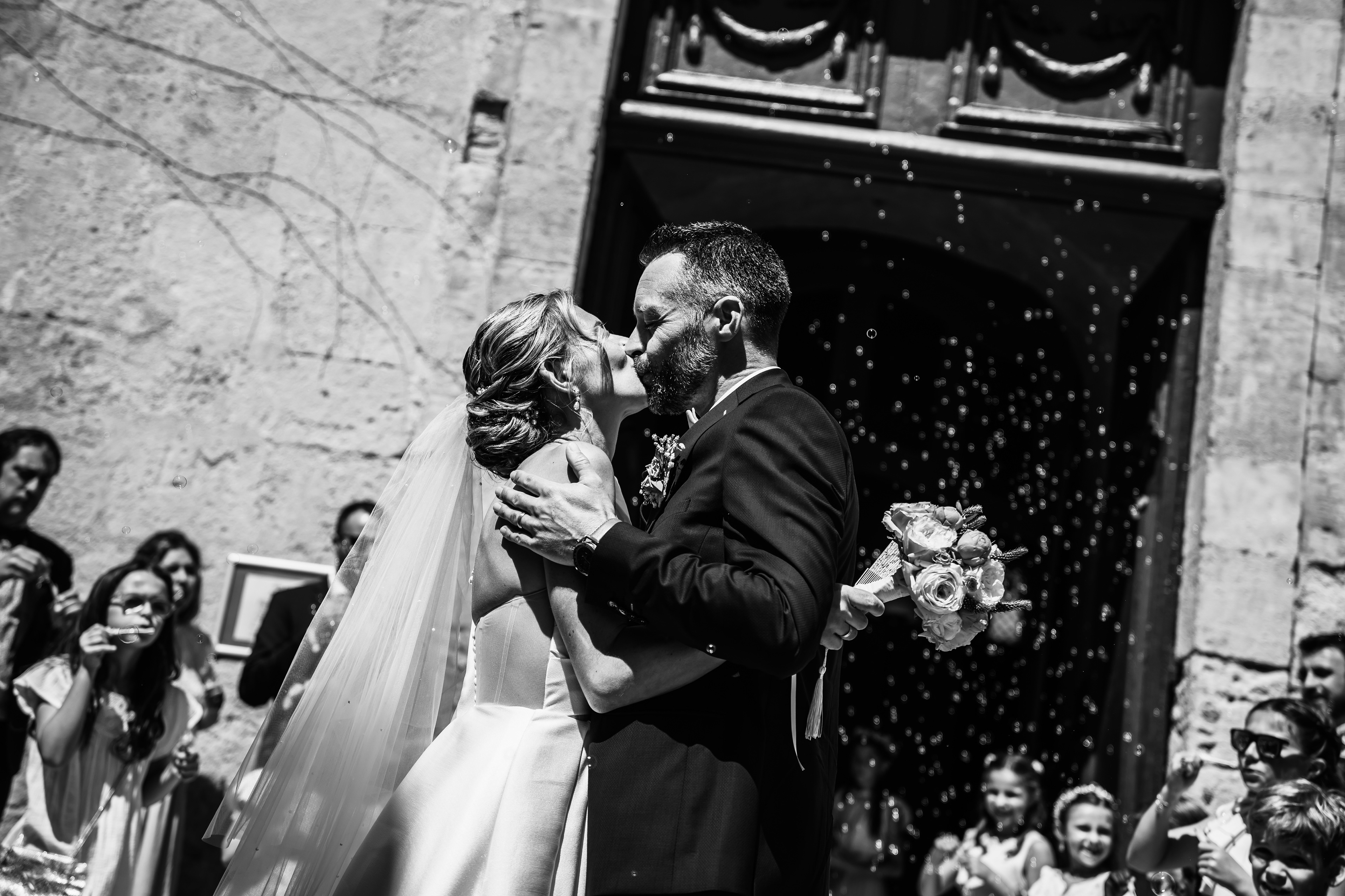 Les mariés s’embrassent à la sortie de l’église entourés de bulles à Béziers