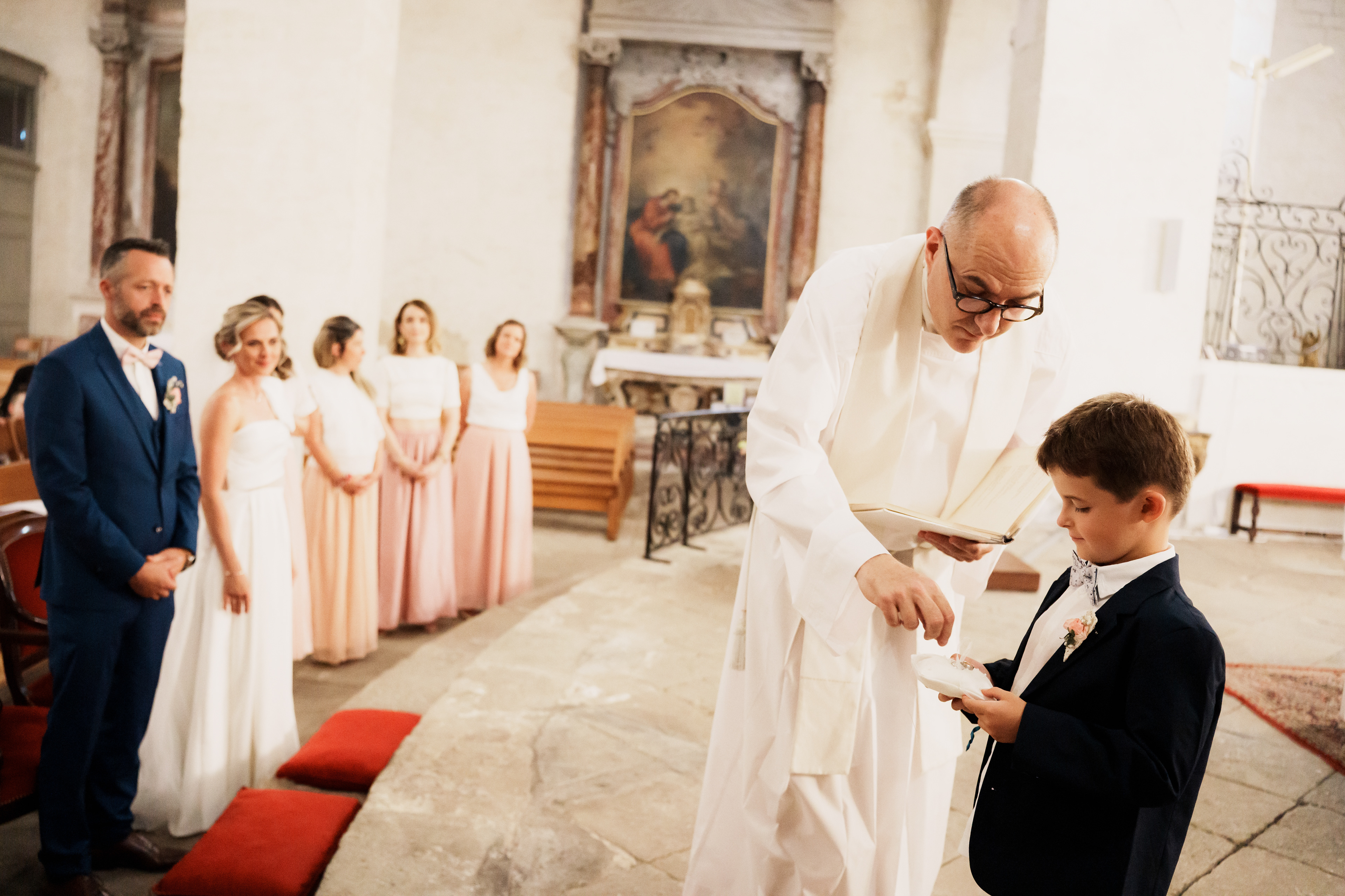 Leur fils tient les alliances à côté du prêtre pendant la cérémonie de mariage à Béziers