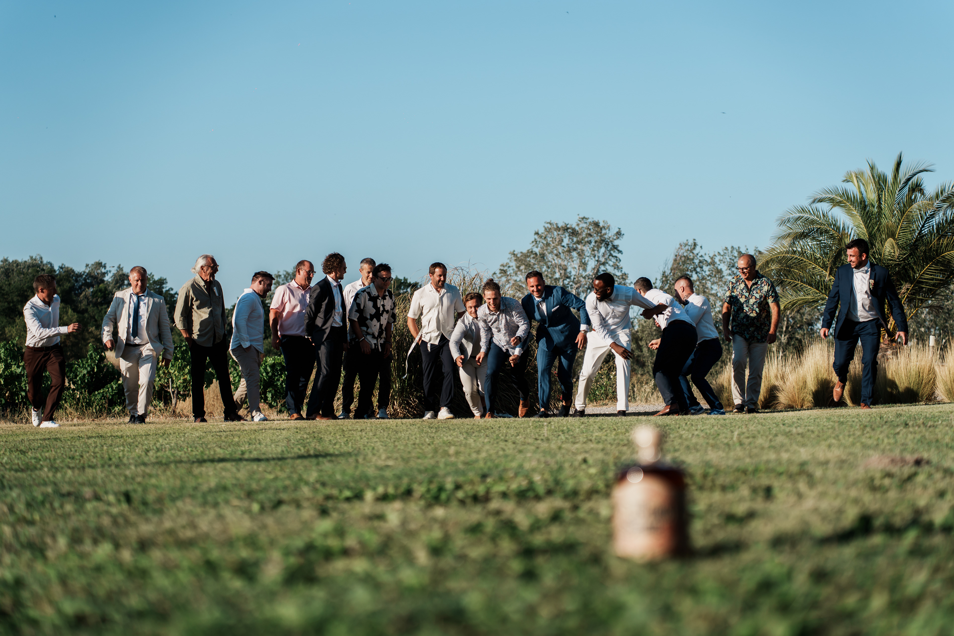 Les hommes participent à une course pour attraper une bouteille de rhum pendant le cocktail de mariage au Domaine de l’Ale à Capestang dans l’Hérault