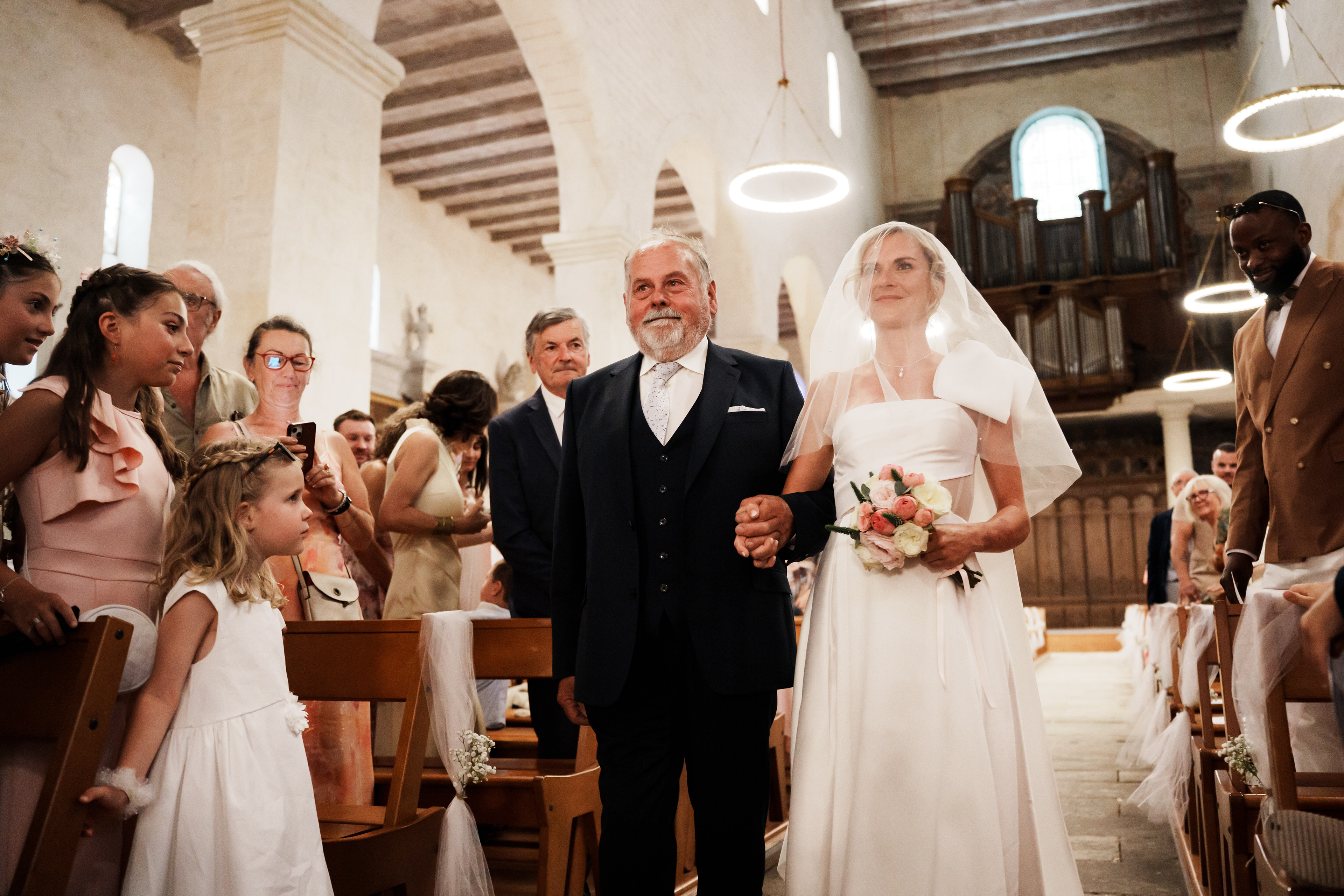 Mariée et son père dans l’allée de l’église en plan rapproché