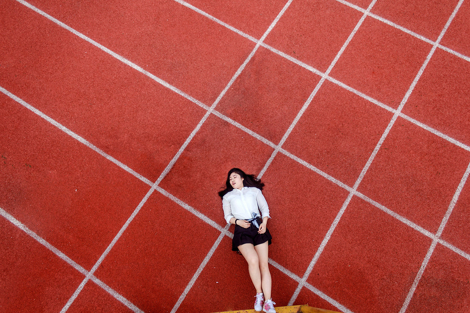 Same of girl lying down on a court with the two others removed