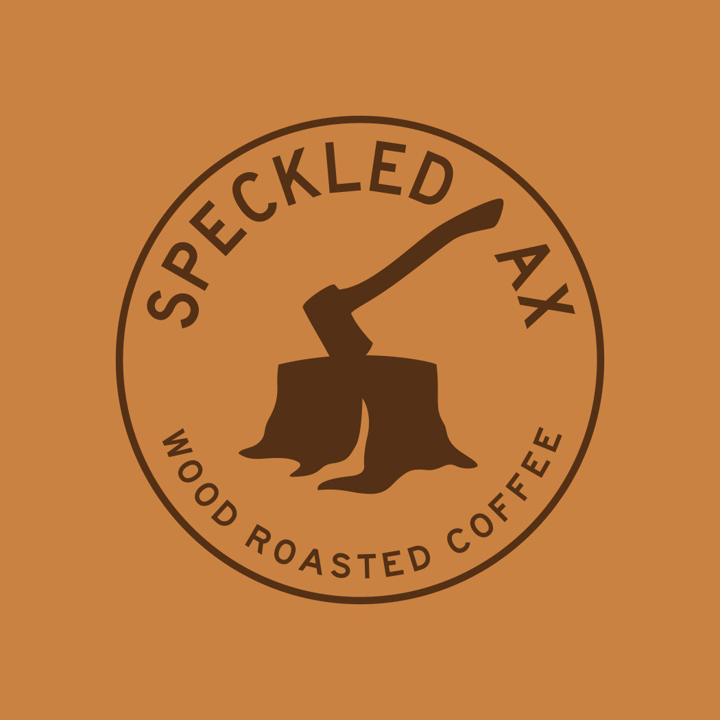 Speckled Ax Wood Ropasted Coffee Portland Maine logo seal badge design with ax in tree stump icon.