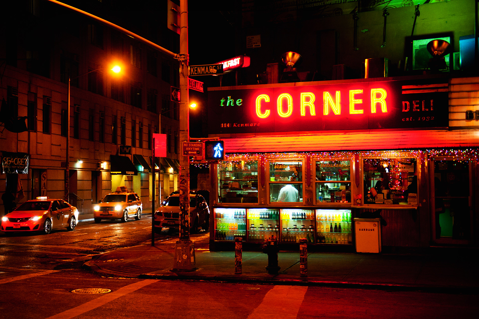 The neon glow of a corner deli lights the streets of Manhattan after dark.