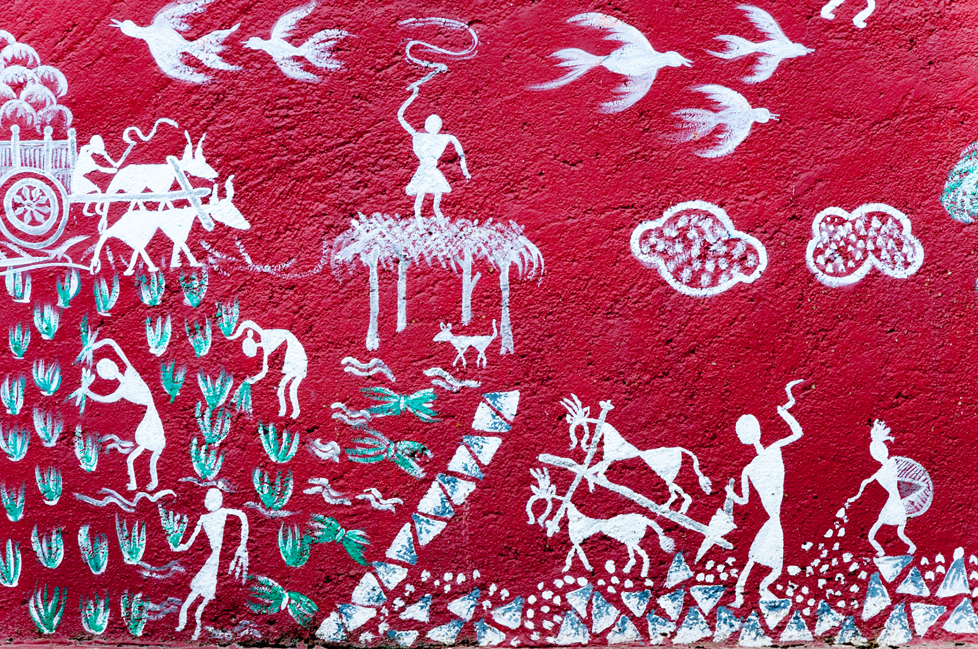 MUMBAI, INDIA – August 9 2018: Farming scenes (sowing, planting, ploughing) depicted on a mural at a Warli big-cat temple inside Sanjay Gandhi National Park. Warli are indigenous tribal people.