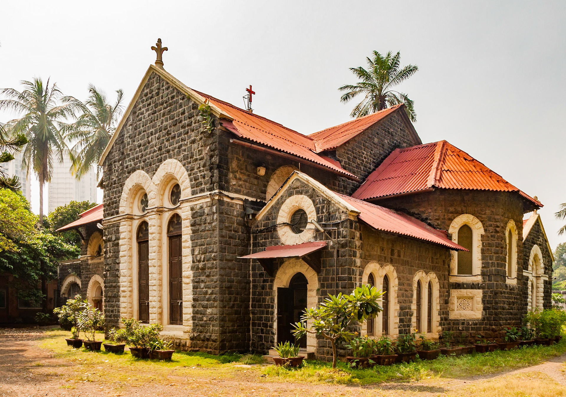 MUMBAI, INDIA – October 23 2017: Stone building and compound of Emmanuel Church (built 1869). Modern buildings in background.
