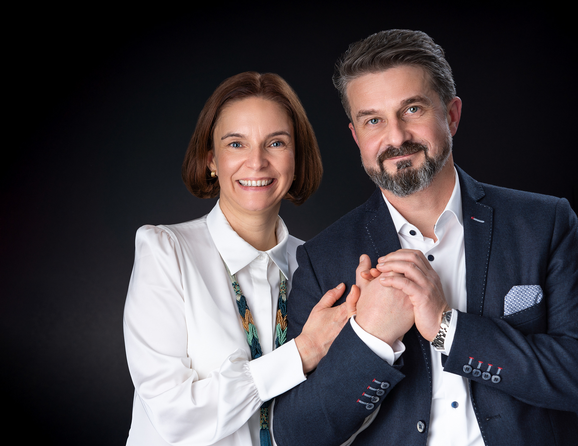 Goście weselni pozują do eleganckiego portretu na czarnym tle wykonanym w mobilnym studio fotograficznym w Krakowie