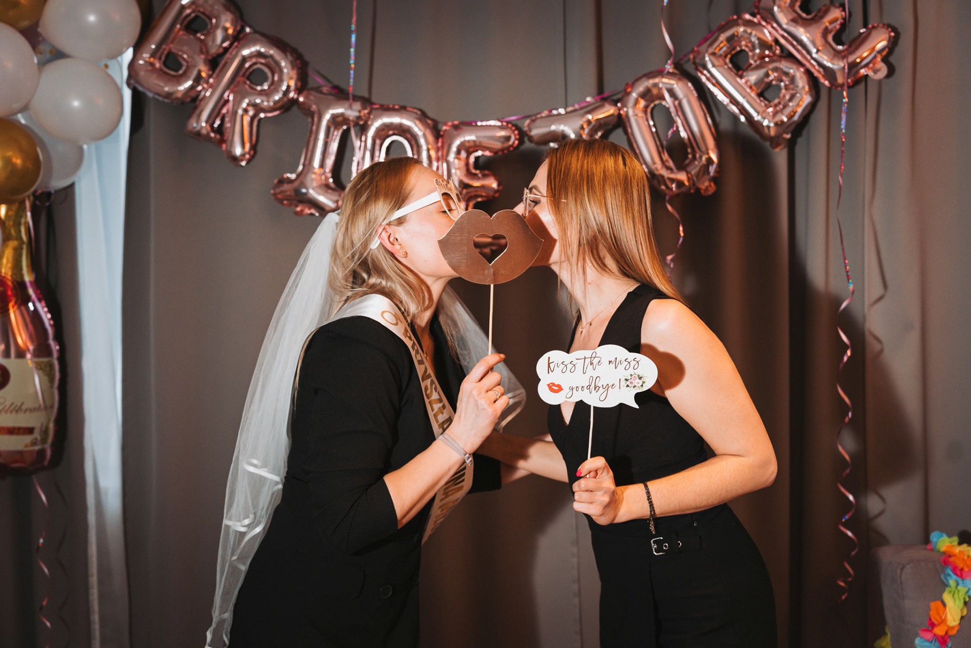 Wieczór panieński w Krakowie – przyszła panna młoda z siostrą w czułym geście pełnym radości. Sesja zdjęciowa wieczoru panieńskiego w krakowskim mieszkaniu. 