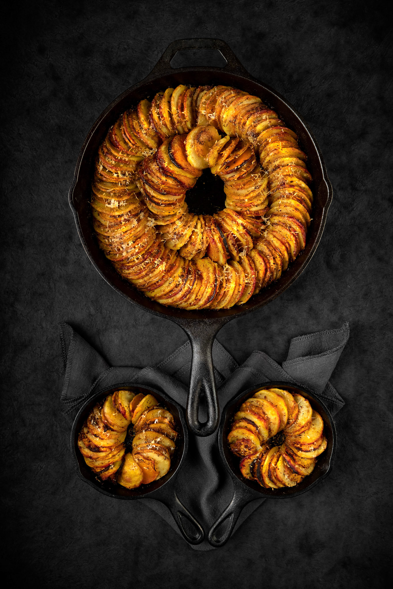 Sliced potatoes and sweet potatoes baked in a cast iron skillet