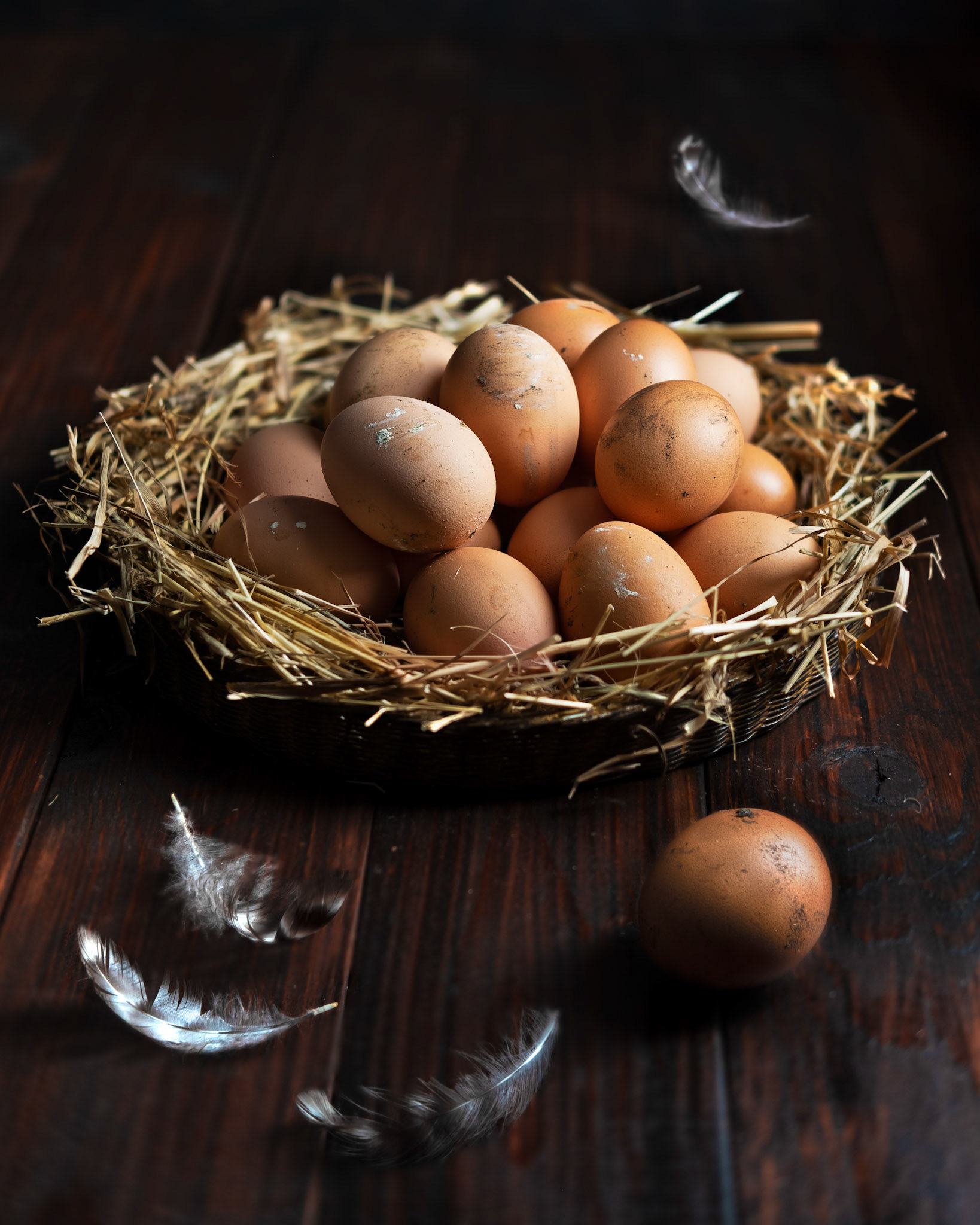 Nest of fresh dirty eggs in a basket