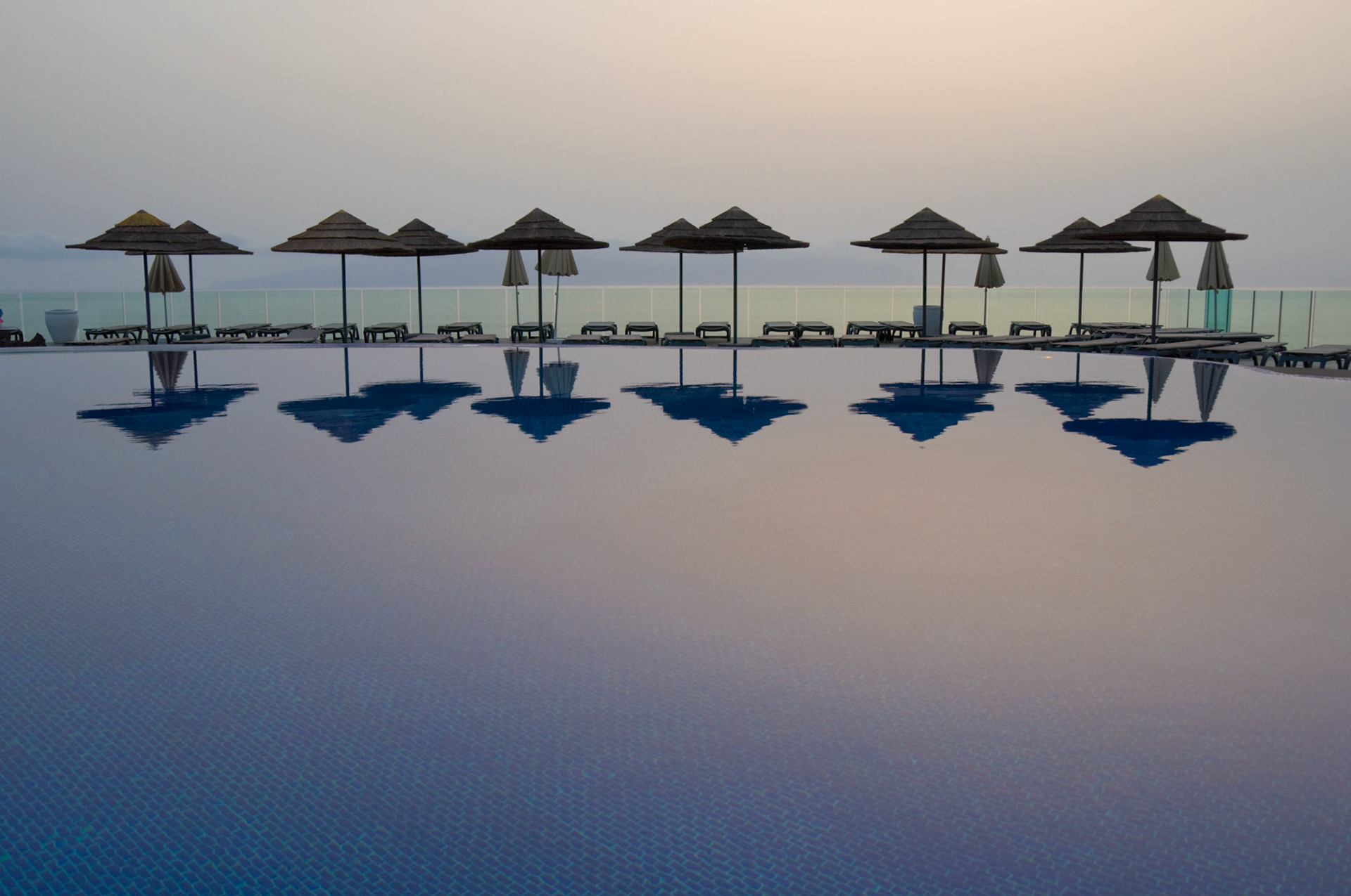 Umbrellas reflected in the pool at sunset