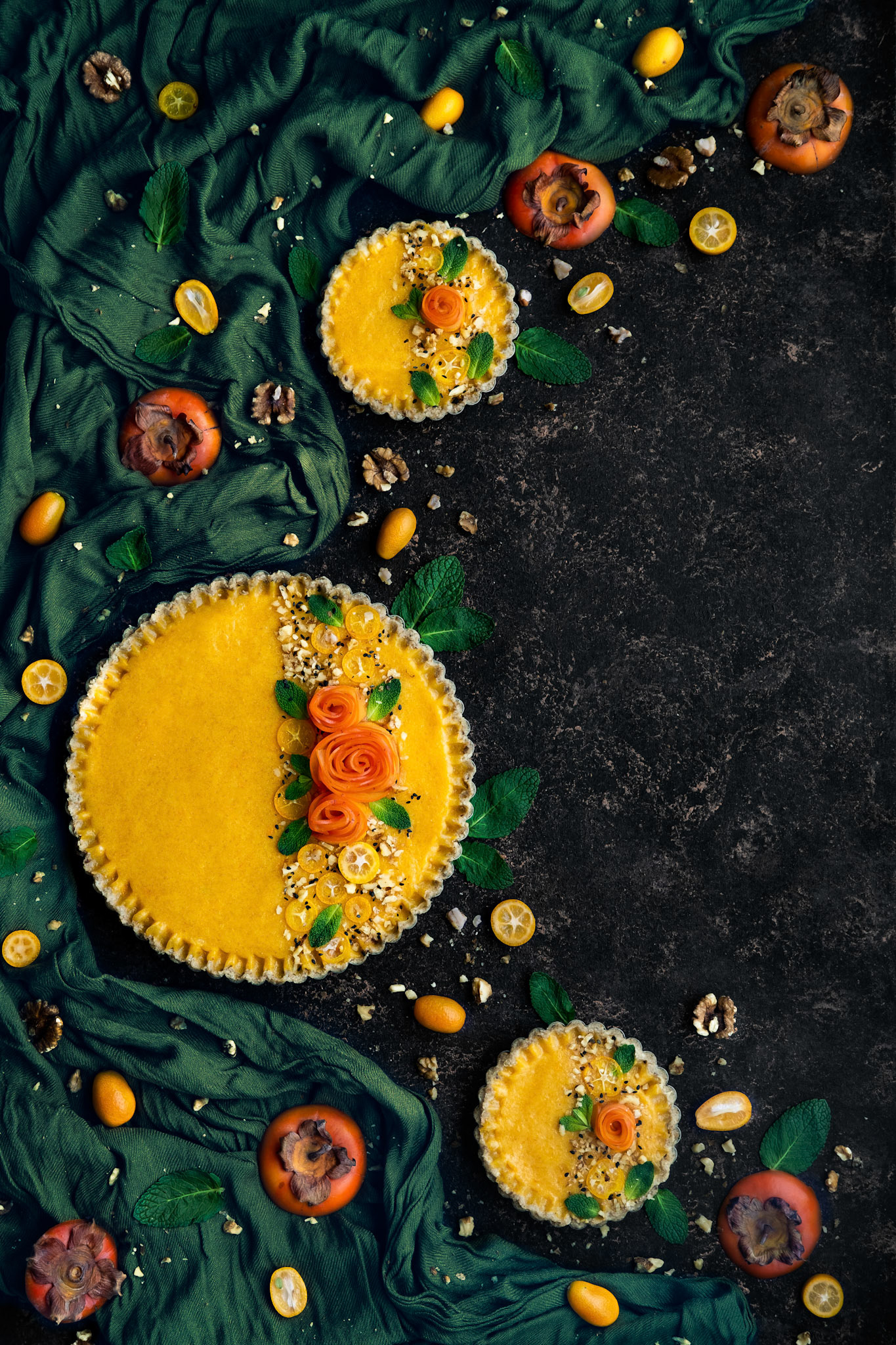 An exotic persimon and kumquat tart with fresh fruits decorations