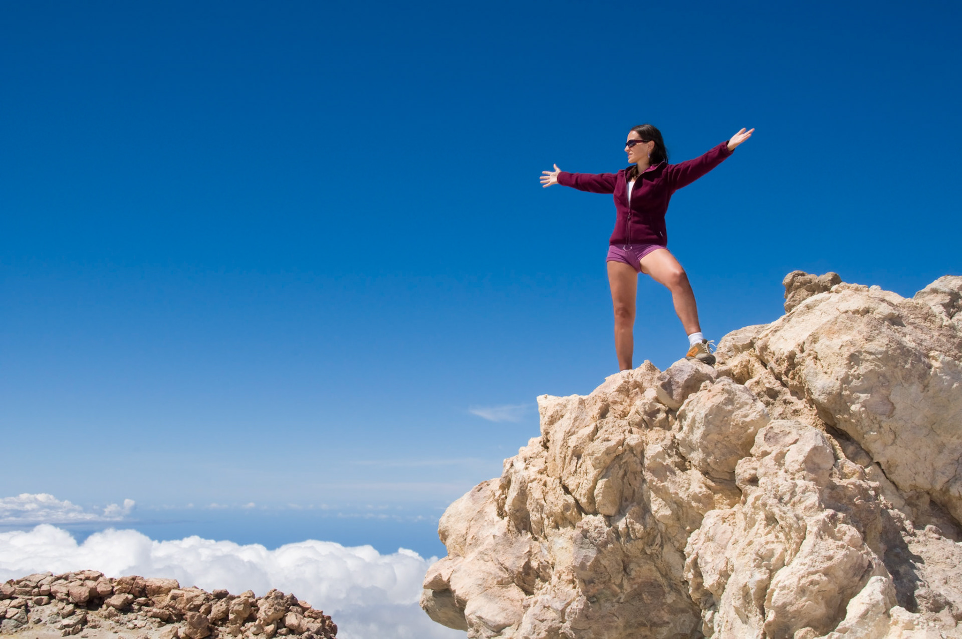 Young woman enjoying the top of the mountain