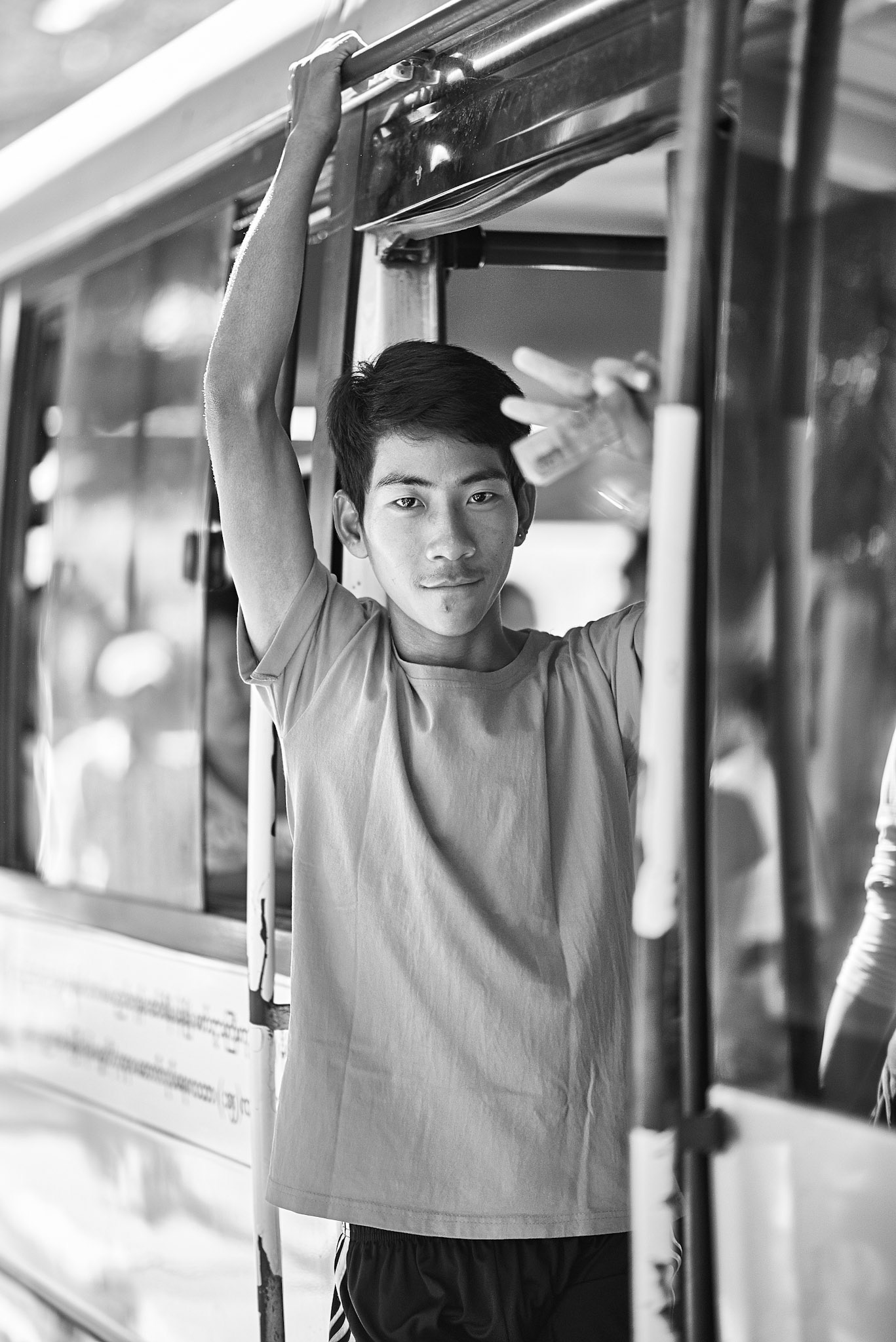 A young man jumping in a bus in Yangon, Myanmar