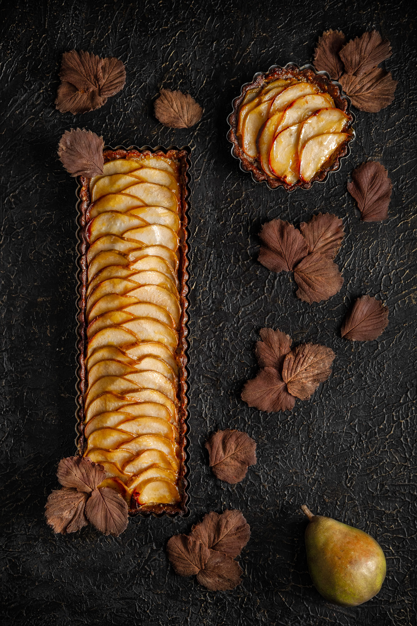 Chocolate almond pear tart decorated with chocolate leaves