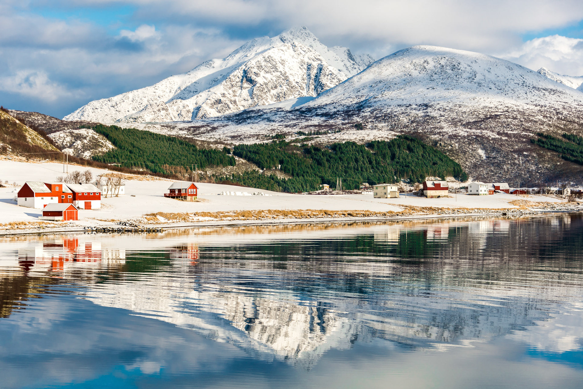 Scenery with reflected cottages and clouds in Lofoten, Norway
