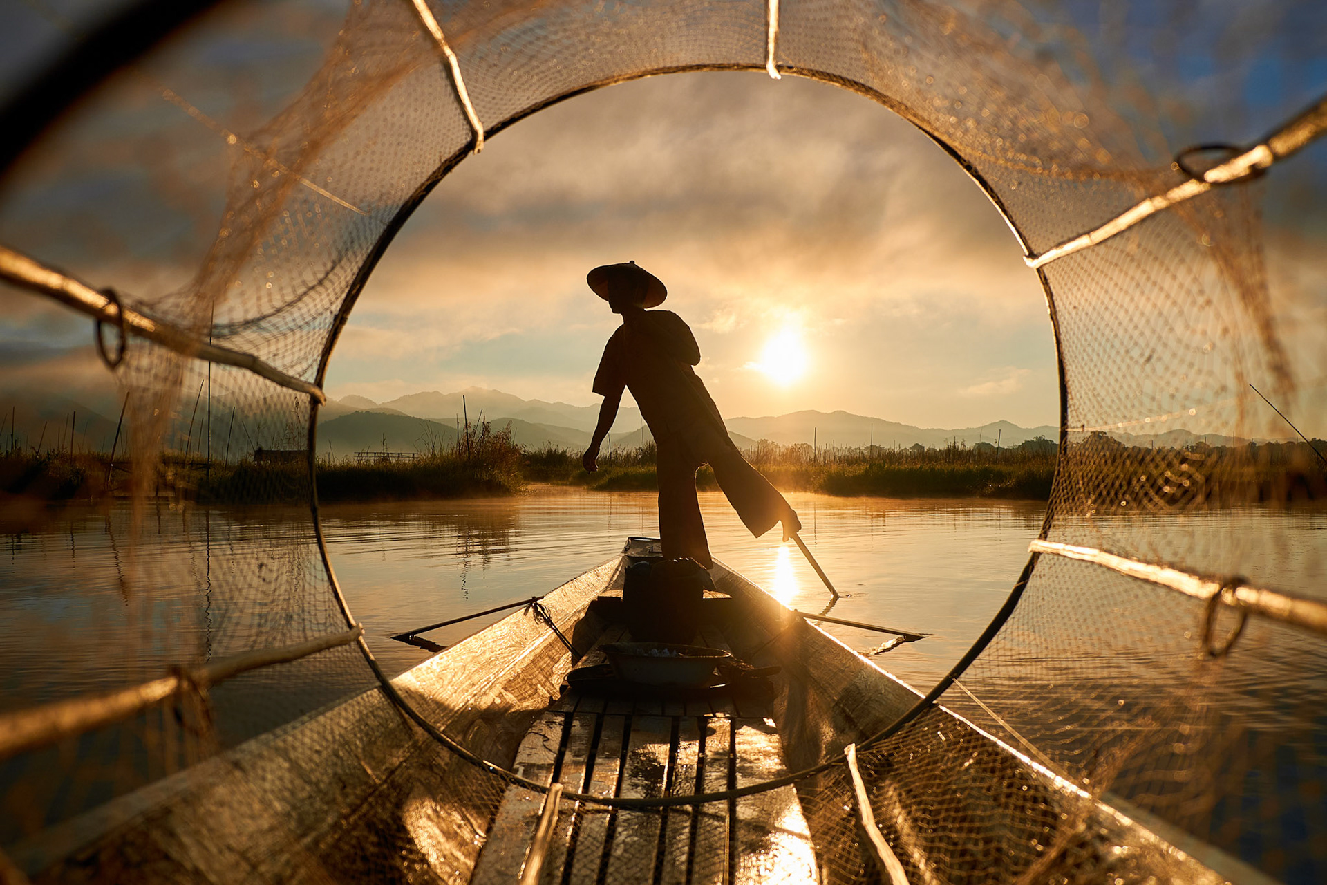 Fisherman from Myanmar seen through fishnet