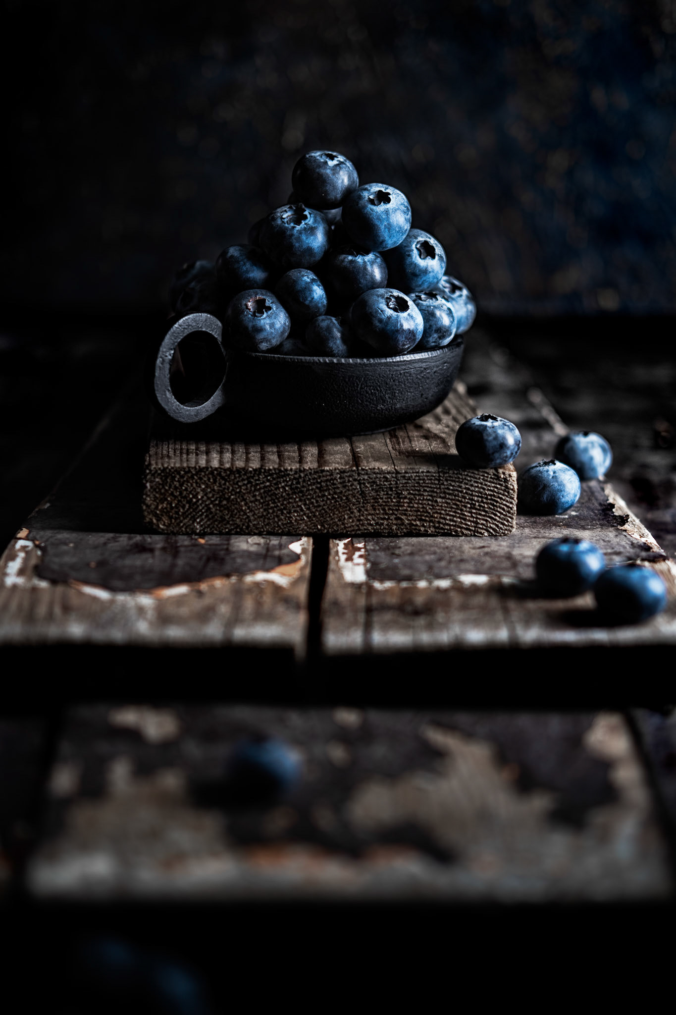 Bowl of blueberries on old wooden planks