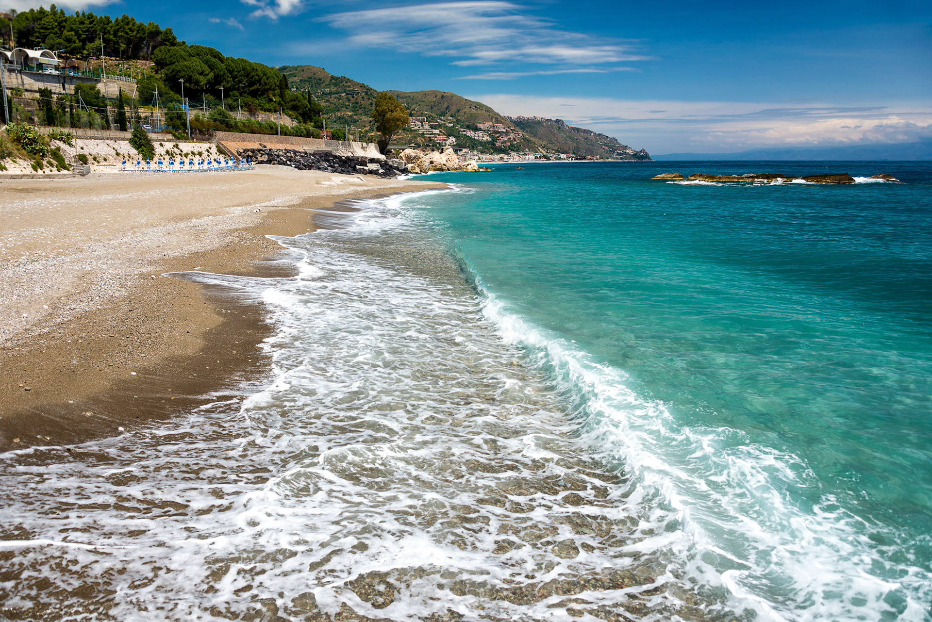 Sunny beach with turquoise water near Taormina Sicily