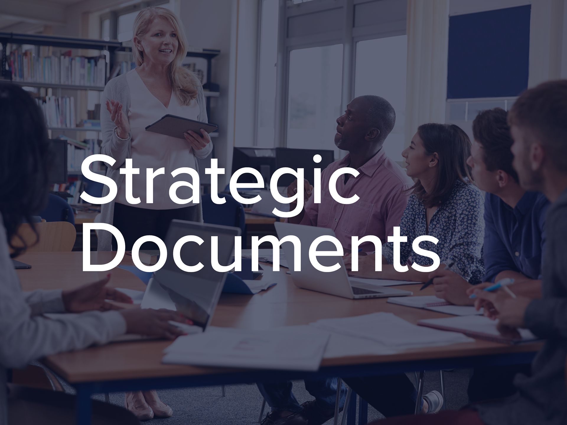 Strategic Documents heading overlaid on a photo of teachers sitting around a table having a meeting