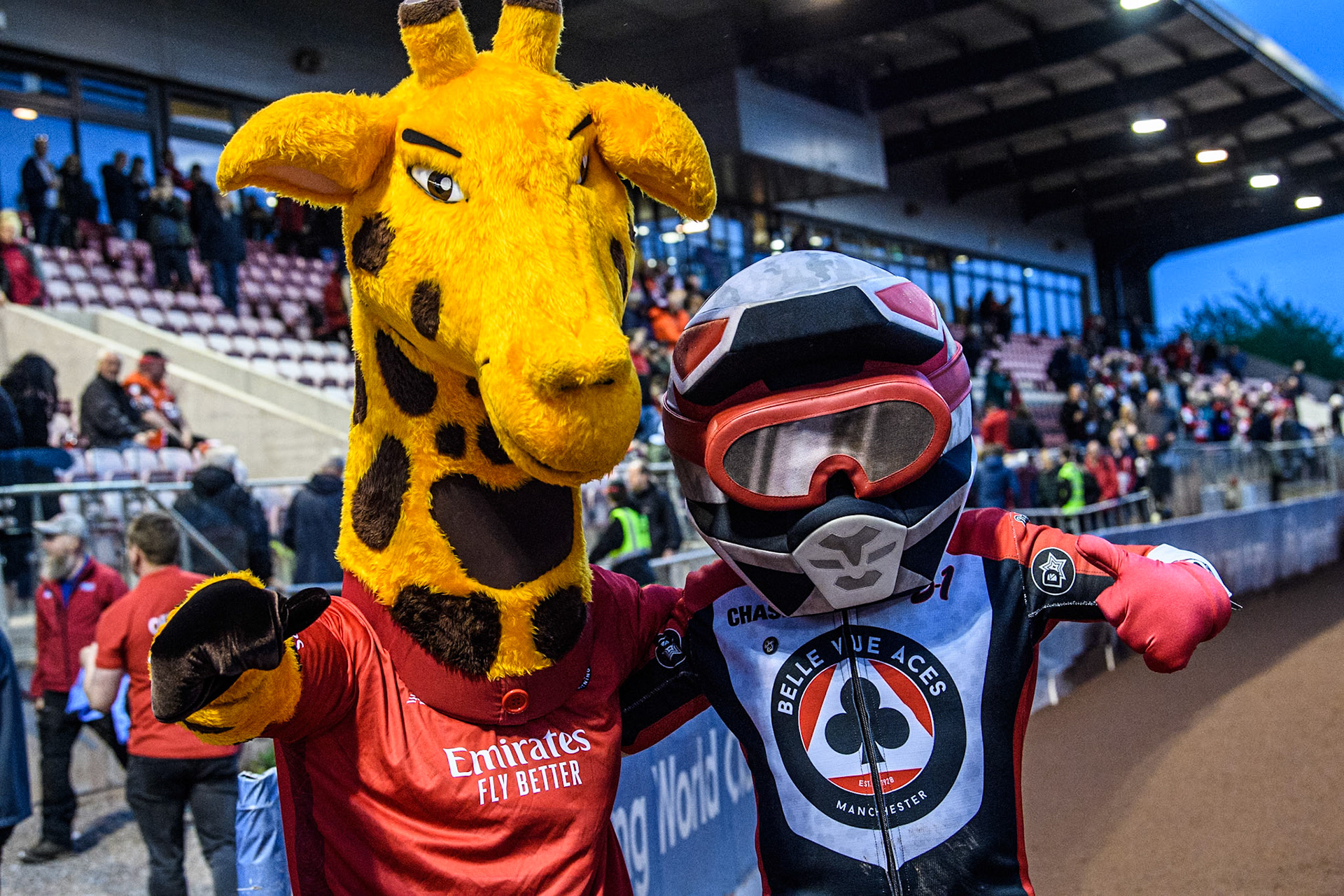 Belle Vue Aces mascot Chase The Ace (Right) meets Lancashire County Cricket Club Mascot Lanky The Giraffe during the Rowe Motor Oil Premiership match between Belle Vue Aces and Oxford Spires at the National Speedway Stadium, Manchester on Monday 13th May 2024. (Photo: Ian Charles | MI News)