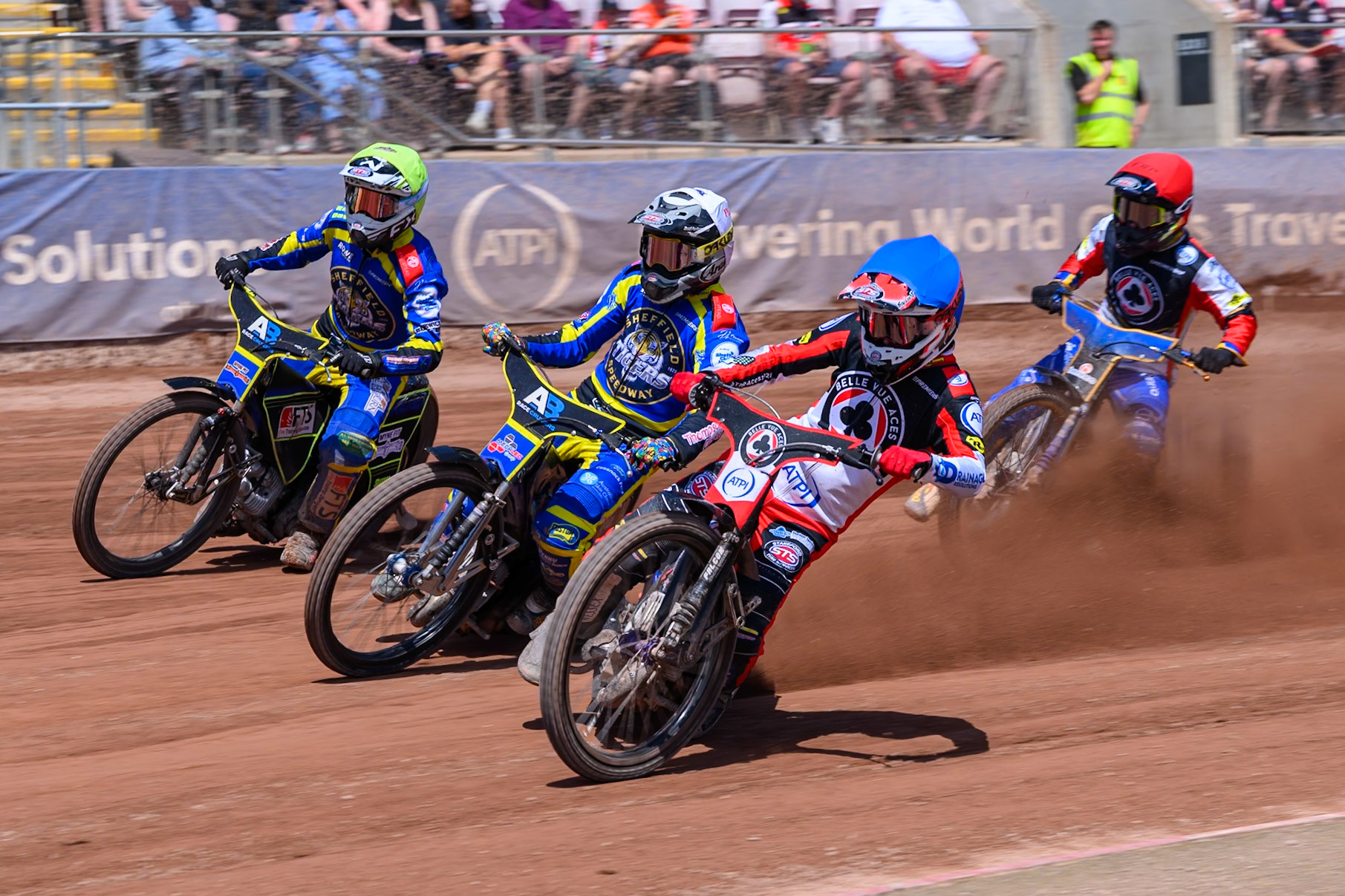 Zach Cook of Belle Vue Aces  in Blue rides inside Josh Pickering of Sheffield Tigers  in White and Jye Etheridge of Sheffield Tigers  in Yellow with Justin Sedgman, Guest Rider for Belle Vue Aces in Red behind during the Rowe Motor Oil Premiership match between Belle Vue Aces and Sheffield Tigers at the National Speedway Stadium, Manchester on Monday 25th May 2026. (Photo: Ian Charles | MI News)