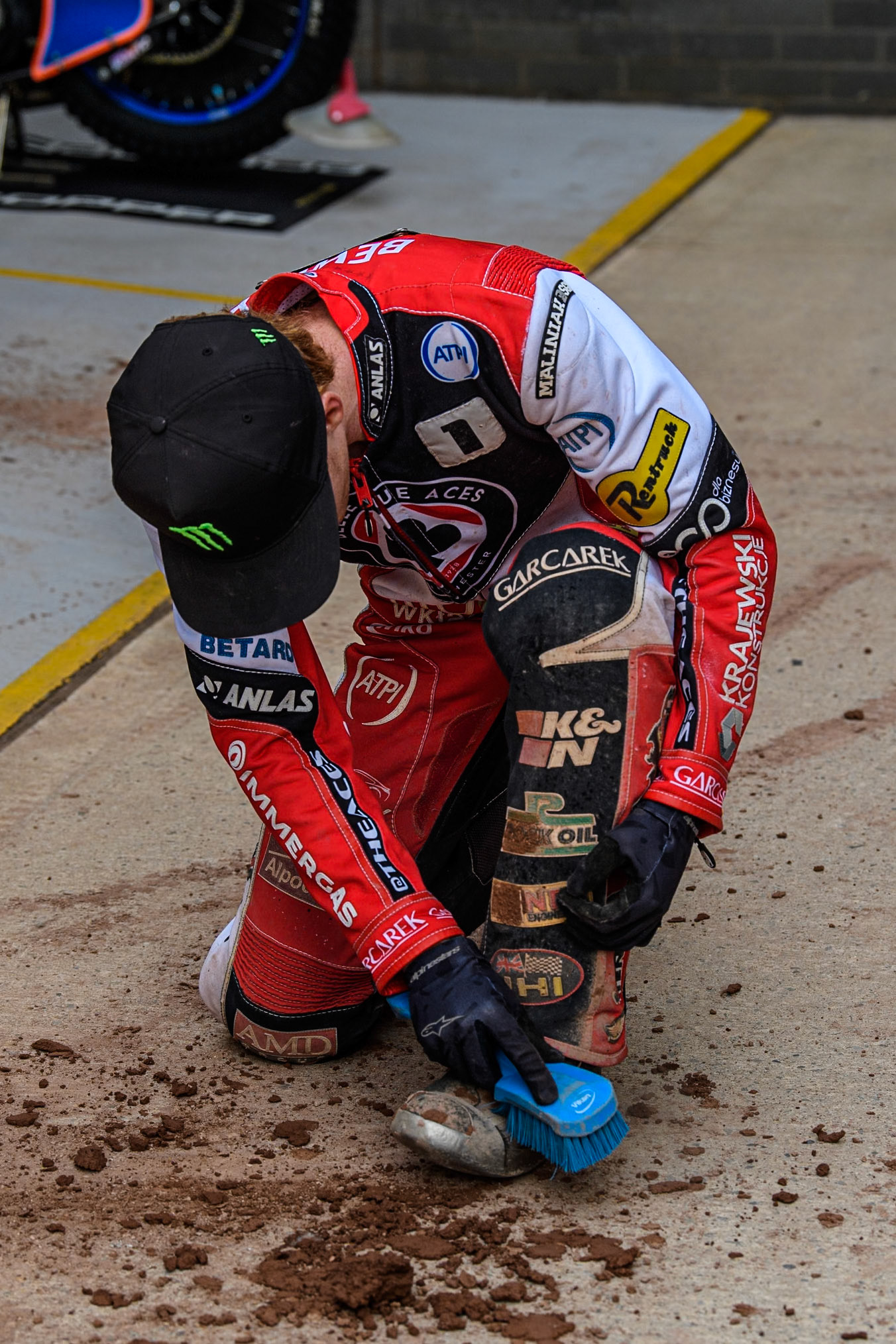 Belle Vue Aces' Dan Bewley   cleans the shale off his kevlars during the Rowe Motor Oil Premiership match between Belle Vue Aces and Sheffield Tigers at the National Speedway Stadium, Manchester on Monday 26th August 2024. (Photo: Ian Charles | MI News)