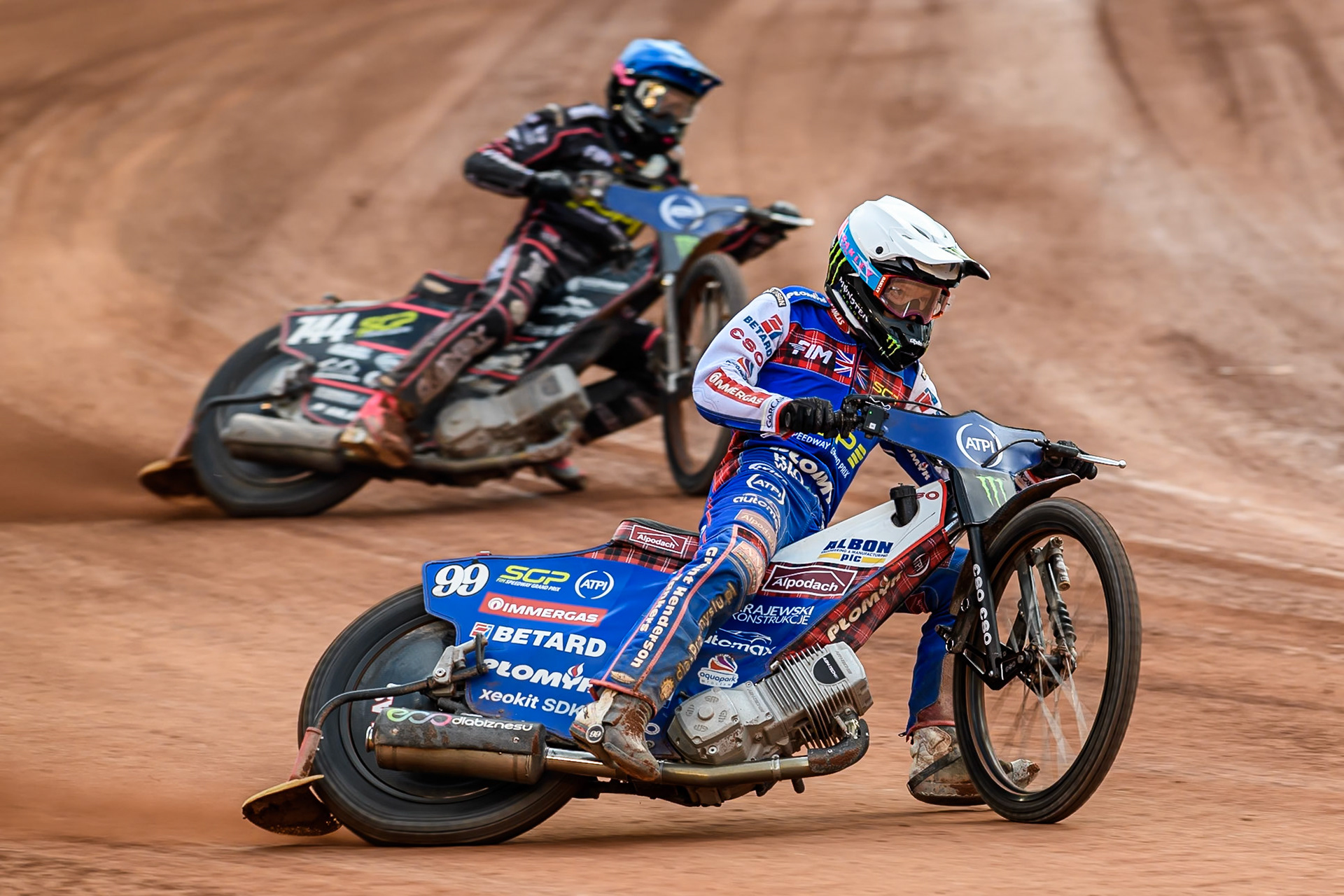 Dan Bewley (99) of Great Britain in White leading Kai Huckenbeck (744) of Germany in Blue during the ATPI FIM Speedway Grand Prix Round 4 at the National Speedway Stadium, Manchester, on Friday 13th June 2025. (Photo: Ian Charles | MI News)