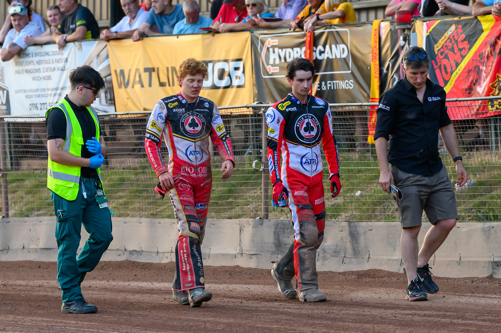 Belle Vue Aces' Dan Bewley (2nd left) walks back to the pits with the medic (Left) and Belle Vue Aces' Zach Cook (2nd right) and Belle Vue Aces' Team Manager Mark Lemon (Right) during the Rowe Motor Oil Premiership match between Leicester Lions and Belle Vue Aces at the Hydroscand Arena, Leicester on Thursday 19th June 2025. (Photo: Ian Charles | MI News)