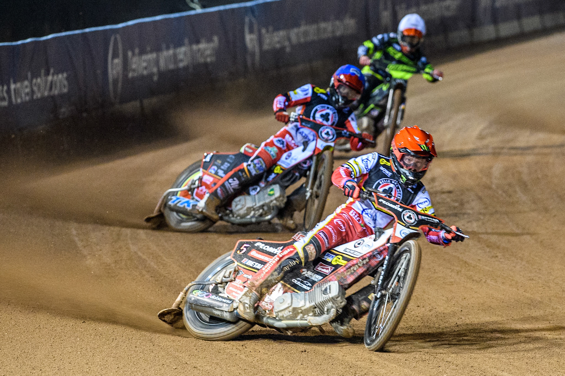 Dan Bewley of Belle Vue Aces in Red leading Tate Zischke of Belle Vue Aces  in Blue and Adam Ellis of Ipswich Witches  in White during the Premiership Cup Quarter Final 1st Leg match between Belle Vue Aces and Ipswich Witches at the National Speedway Stadium, Manchester on Monday 24th March 2025. (Photo: Ian Charles | MI News)