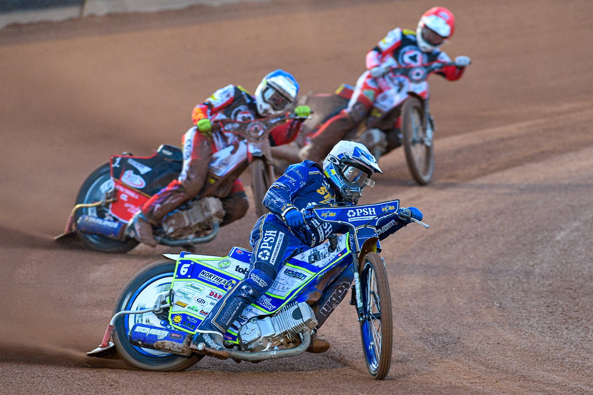 Chris Harris of Kings Lynn Stars in White leading Jake Mulford of Belle Vue Aces in Blue and Tate Zischke of Belle Vue Aces in Red during the Rowe Motor Oil Premiership match between Belle Vue Aces and King's Lynn Stars at the National Speedway Stadium, Manchester on Monday 5th April 2025. (Photo: Ian Charles | MI News)
