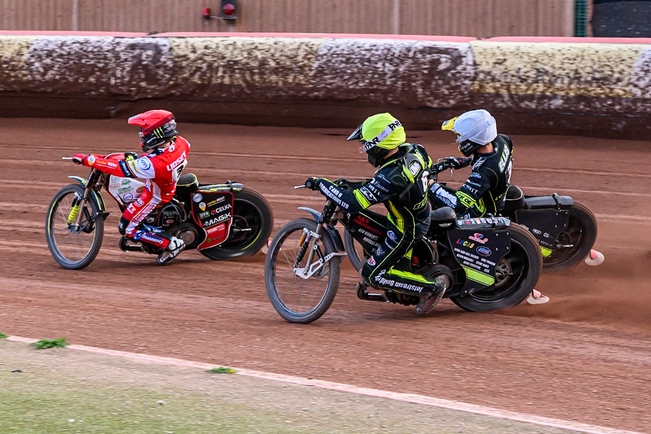 Ipswich Witches' Dan Thompson  in Yellow and Ipswich Witches' Adam Ellis  chasing Belle Vue Aces' Jaimon Lidsey  in Red during the Rowe Motor Oil Premiership match between Belle Vue Aces and Ipswich Witches at the National Speedway Stadium, Manchester on Monday 30th June 2025. (Photo: Ian Charles | MI News)