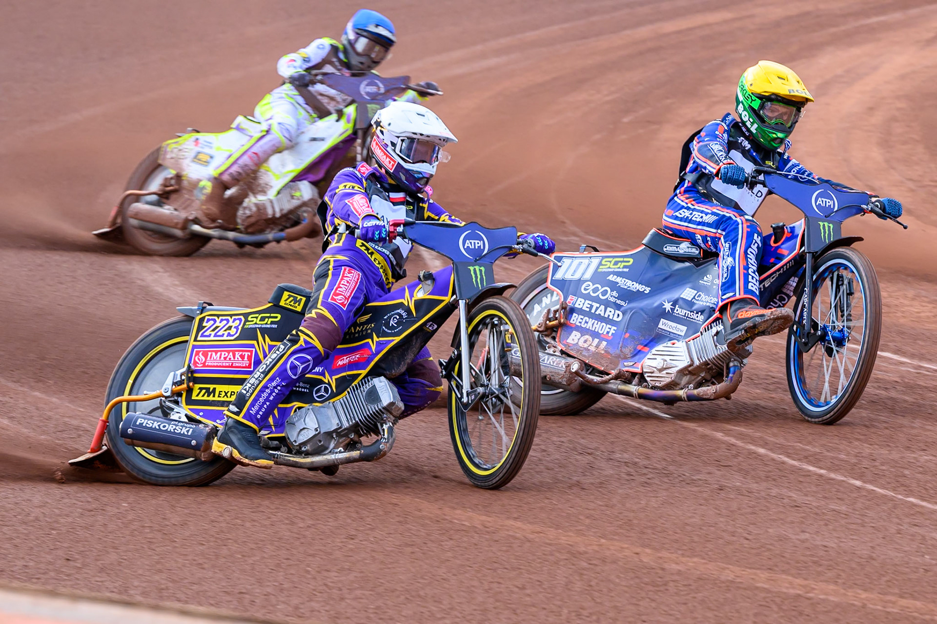 Kacper Woryna (223) of Poland in White rides outside Brady Kurtz (101) of Australia in Yellow with Wild Card Tom Brennan (16) of Great Britain  in Blue behind during the ATPI  FIM Speedway GP of Manchester at the National Speedway Stadium, Manchester on Friday 5th June 2026. (Photo: Ian Charles | MI News)