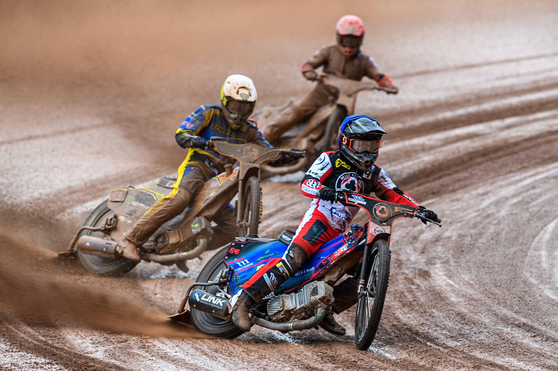 Belle Vue Aces' Ben Cook in Blue leading Chris Holder in White and Sheffield Tigers' Guest rider Tom Brennan in Yellow during the Rowe Motor Oil Premiership match between Belle Vue Aces and Sheffield Tigers at the National Speedway Stadium, Manchester on Monday 27th May 2024. (Photo: Ian Charles | MI News)
