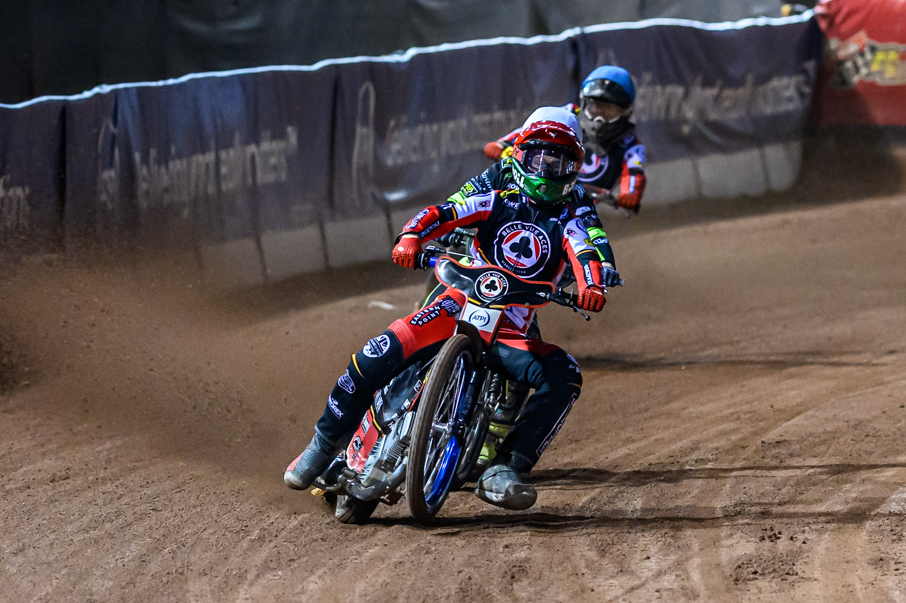 Brady Kurtz of Belle Vue Aces  in Red picks up some drive ahead of Tom Brennan of Ipswich Witches  in White and Norick Blödorn of Belle Vue Aces  in Blue during the Rowe Motor Oil Premiership Play Off Semi Final 1  (1st Leg)  between Belle Vue Aces and Ipswich Witches at the National Speedway Stadium, Manchester on Monday 8th September 2025. (Photo: Ian Charles | MI News)