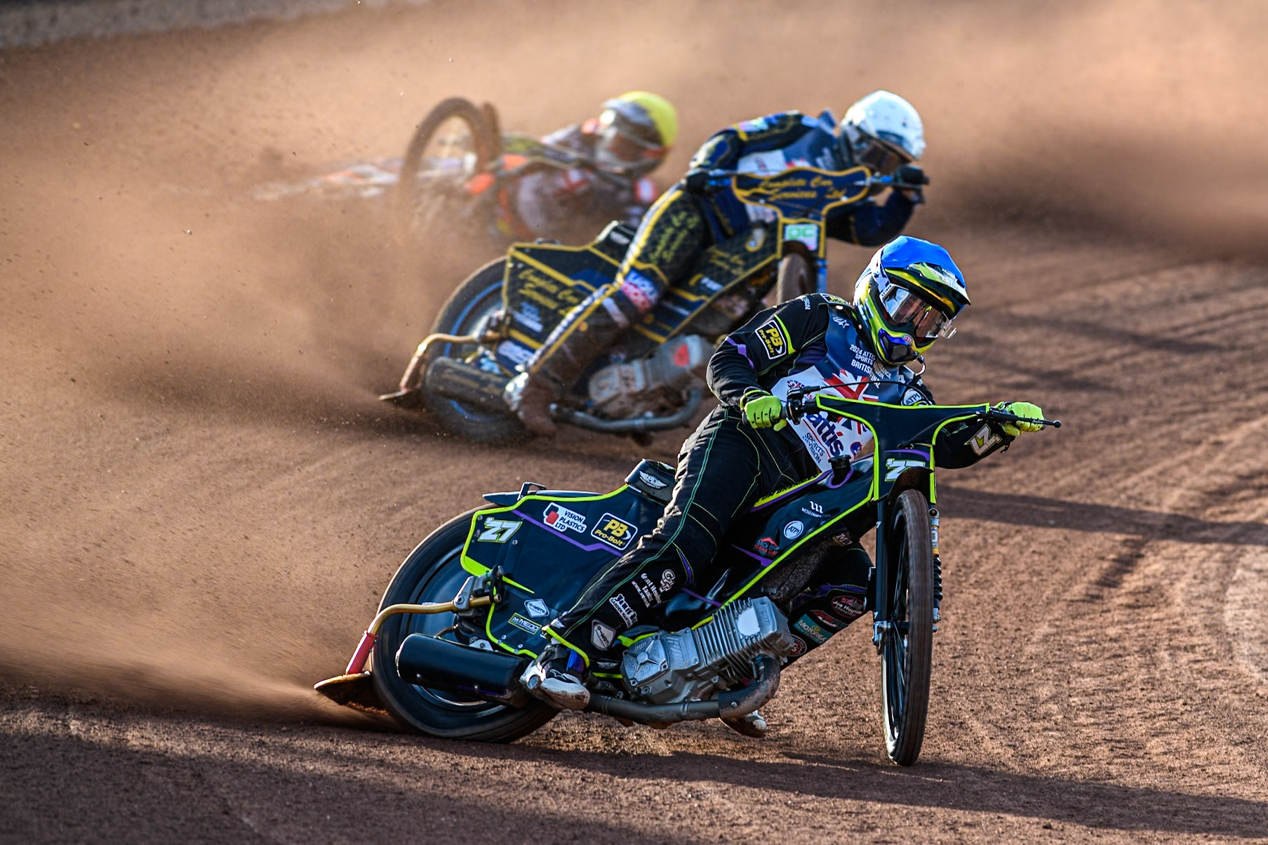 Tom Brennan in Blue leading Kyle Howarth in White as Jordan Jenkins slides off behind during the Attis Insurance Sports Division British Speedway Championship Final at the National Speedway Stadium, Manchester on Saturday 8th June 2024. (Photo: Ian Charles | MI News)