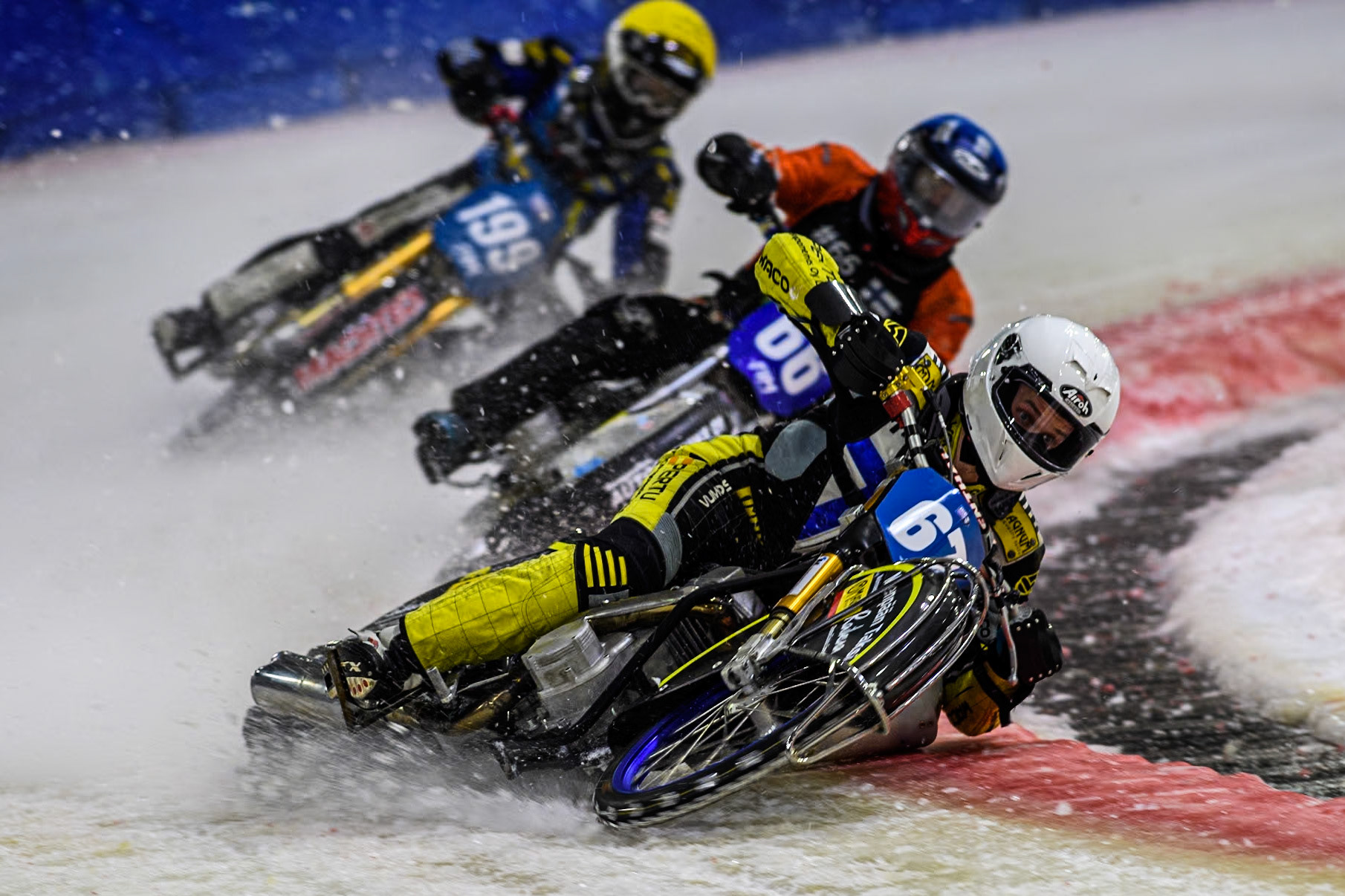Finland's Heikki Huusko (67) in White leading Finland's Aki Ala-Riihimäki (66) in Blue and Sweden's Martin Haarahiltunen (199)  in Yellow during the FIM Ice Speedway Gladiators World Championship Final 3 at Ice Rink Thialf, Heerenveen on Saturday 6th April 2024. (Photo: Ian Charles | MI News)