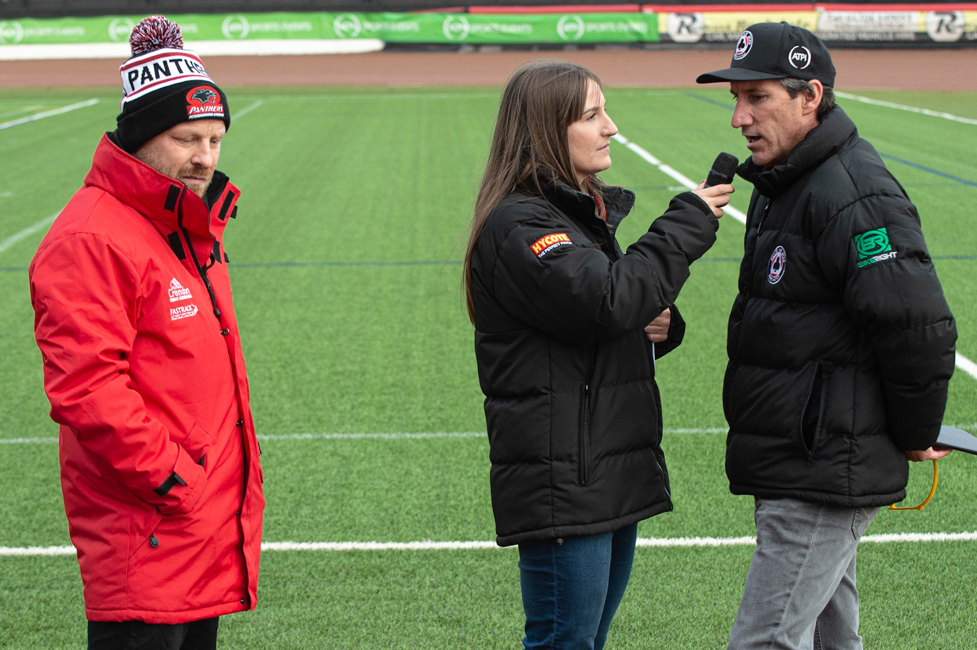 Photo by Ian Charles:

Carl Johnson  (left) waits whilst Hayley interviews Mark Lemon 

Belle Vue Aces v Peterborough Panthers, British Speedway Premiership, National Speedway Stadium, Manchester, Thursday, 13, June, 2019