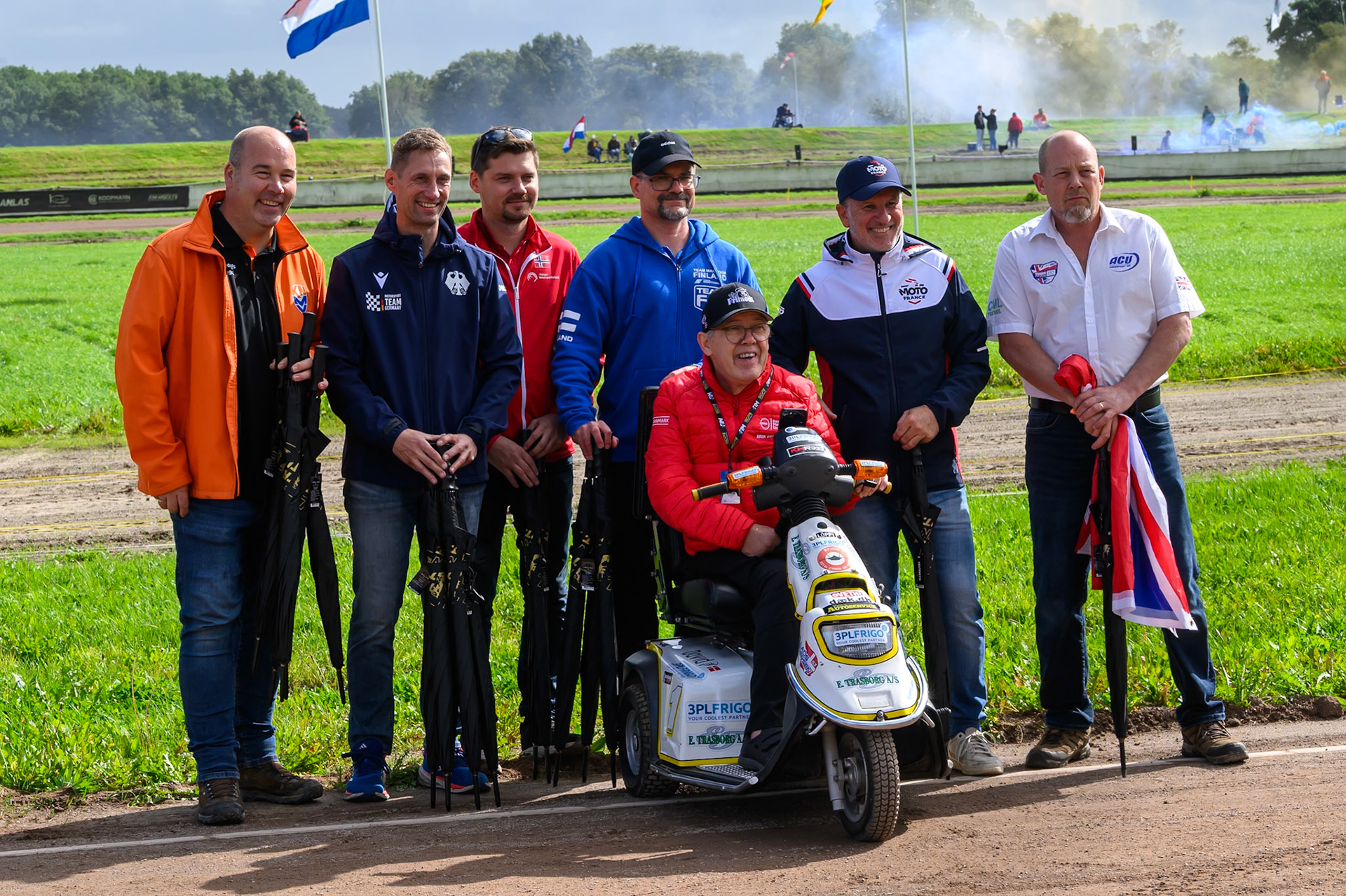 The Team Managers: (Standing L to R) Patrick Roth, Team Manager of Netherlands, Jörg Tebbe, Team Manager of Germany, Kenneth Klipper Smith, Team Manager of Norway, Tomi Nevanperä, Team Manager of Finland, Laurent Sambarrey , Team Manager of France and Mitch Godden, Team Manager of Great Britain  with Erik Gundersen, Team Manager of Denmark  in the motorised chair during the FIM Long Track of Nations 2026 at the Speed Centre Roden in the Netherlands on Sunday 20th September 2026. (Photo: Ian Charles | MI News)