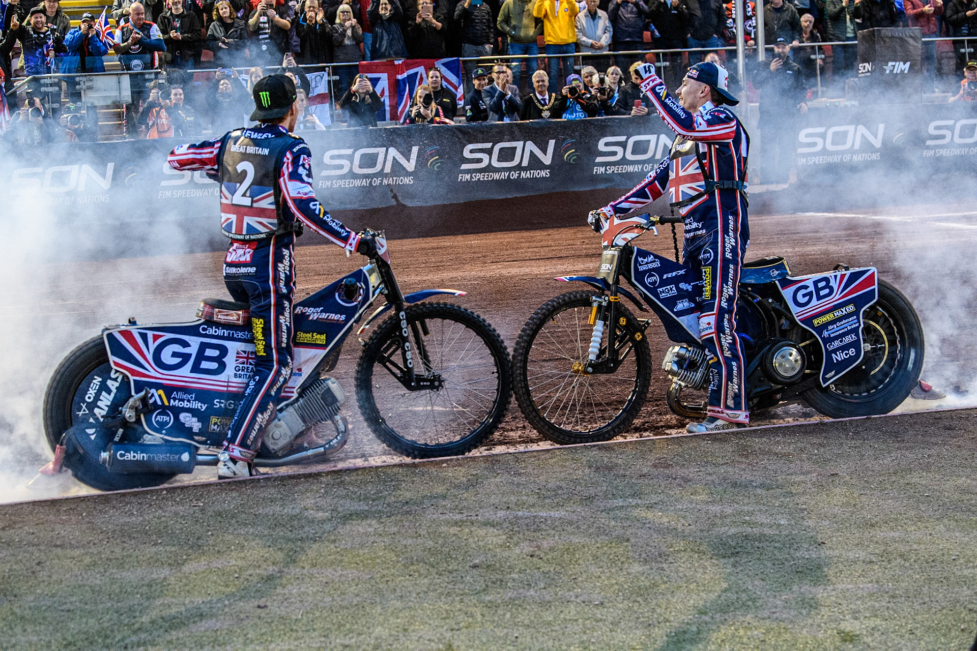 Dan Bewley of Great Britain (Left) and Robert Lambert of Great Britain celebrate with a burnout during the Monster Energy FIM Speedway of Nation Final at the National Speedway Stadium, Manchester on Saturday 13th July 2024. (Photo: Ian Charles | MI News)