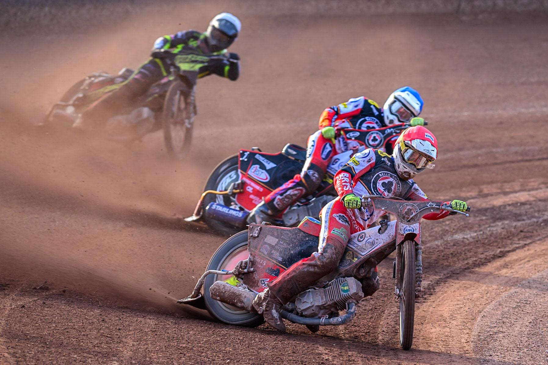 Belle Vue Aces' Tate Zischke  in Red leading Belle Vue Aces' Jake Mulford  in Blue and Ipswich Witches' Dan Thompson  in White during the Rowe Motor Oil Premiership match between Belle Vue Aces and Ipswich Witches at the National Speedway Stadium, Manchester on Monday 30th June 2025. (Photo: Ian Charles | MI News)