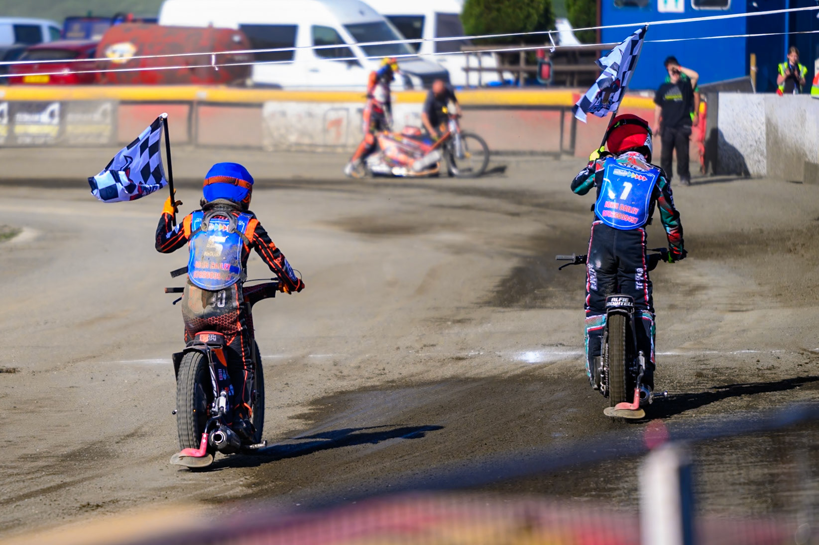 Jack Smith of Buxton Bulls in Blue and Alfie Bowtell of Buxton Bulls  in Red with the team flags after their match winning heat win during the National Development League Challenge match between Buxton Bulls and Stoke Potters at Hi-Edge Speedway, Buxton on Sunday 24th May 2026. (Photo: Ian Charles | MI News)