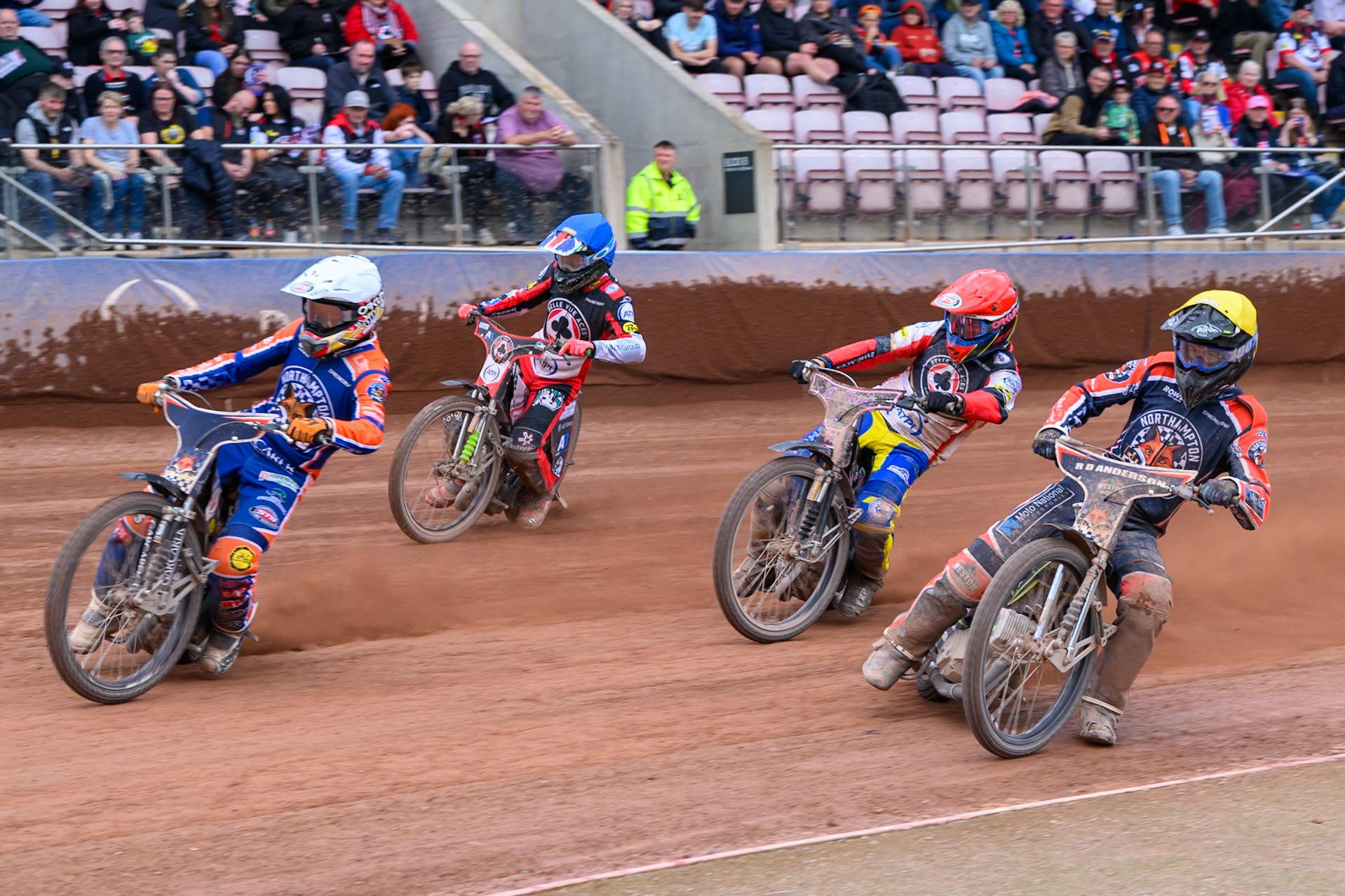 Nicolai Klindt of Northampton Foxes in White leading Kye Thomson of Northampton Foxes  in Yellow, Leon Flint, Guest Rider for Belle Vue Aces in Red and Will Cairns of Belle Vue Aces in Blue during the Rowe Motor Oil Premiership match between Belle Vue Aces and Northampton Foxes at the National Speedway Stadium, Manchester on Monday 4th May 2026. (Photo: Ian Charles | MI News)