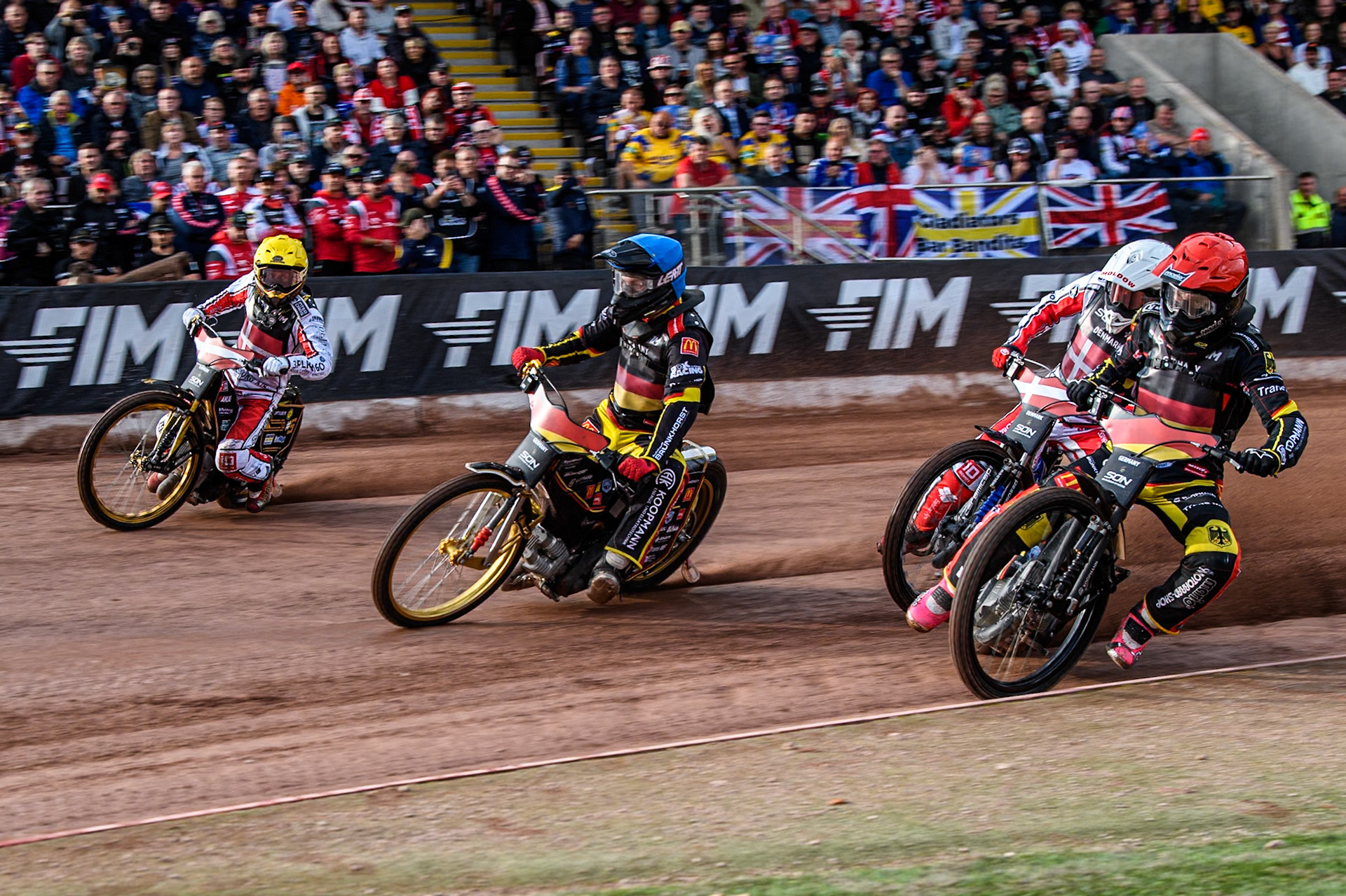 GERMANY v DENMARK: Kai Huckenbeck of Germany in Red rides inside Norick Blödorn of Germany and Anders Thomsen of Denmark in Yellow with Rasmus Jensen of Denmark in White behind during the Monster Energy FIM Speedway of Nation Final at the National Speedway Stadium, Manchester on Saturday 13th July 2024. (Photo: Ian Charles | MI News)