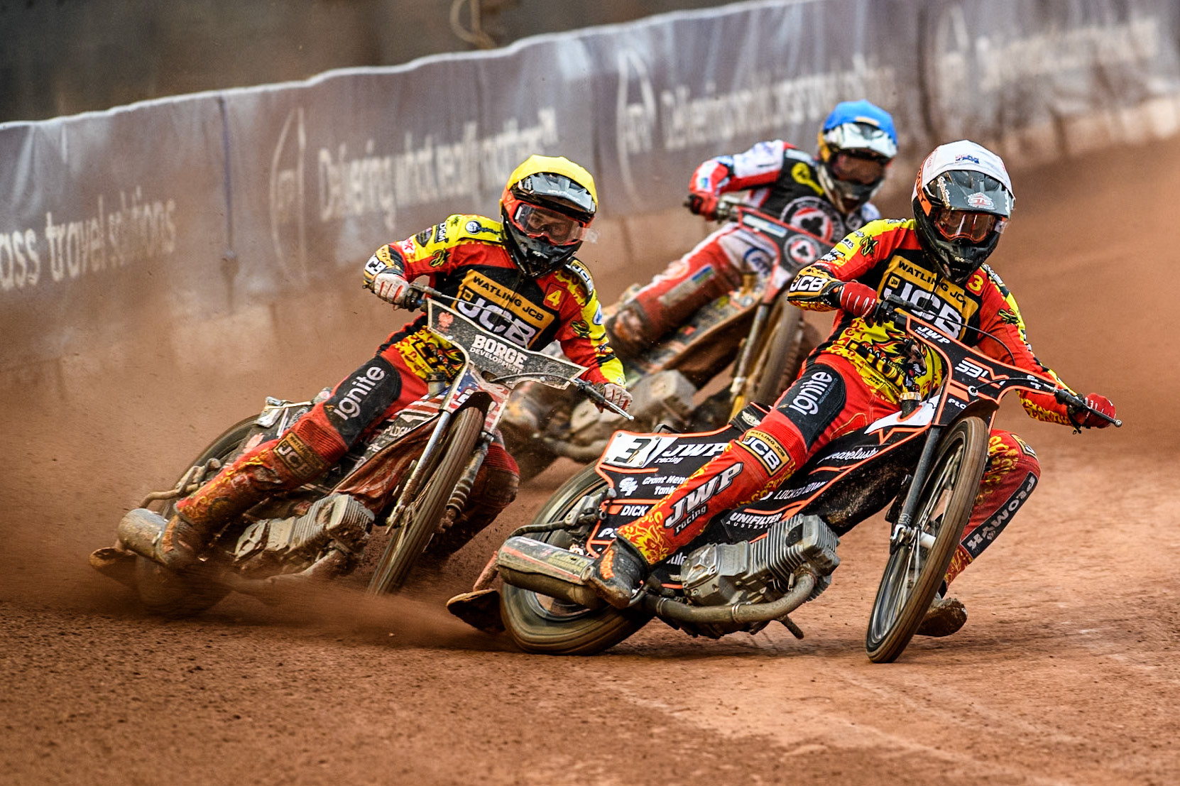 Leicester Lions' Sam Masters in White leading Leicester Lions' Luke Becker in Yellow and Belle Vue Aces' Connor Mountain in Blue during the Rowe Motor Oil Premiership match between Belle Vue Aces and Leicester Lions at the National Speedway Stadium, Manchester on Monday 24th June 2024. (Photo: Ian Charles | MI News)