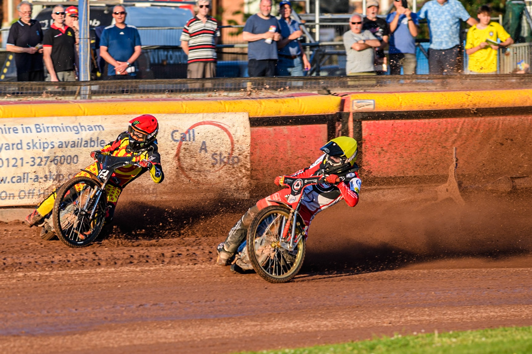 Belle Vue Aces' Brady Kurtz falls on the first turn of the opening lap behind Birmingham Brummies' Freddie Lindgren in Red and Belle Vue Aces' Norick Blodorn in Yellow during the Rowe Motor Oil Premiership match between Birmingham Brummies and Belle Vue Aces at Perry Bar Stadium, Birmingham on Monday 29th July 2024. (Photo: Ian Charles | MI News)