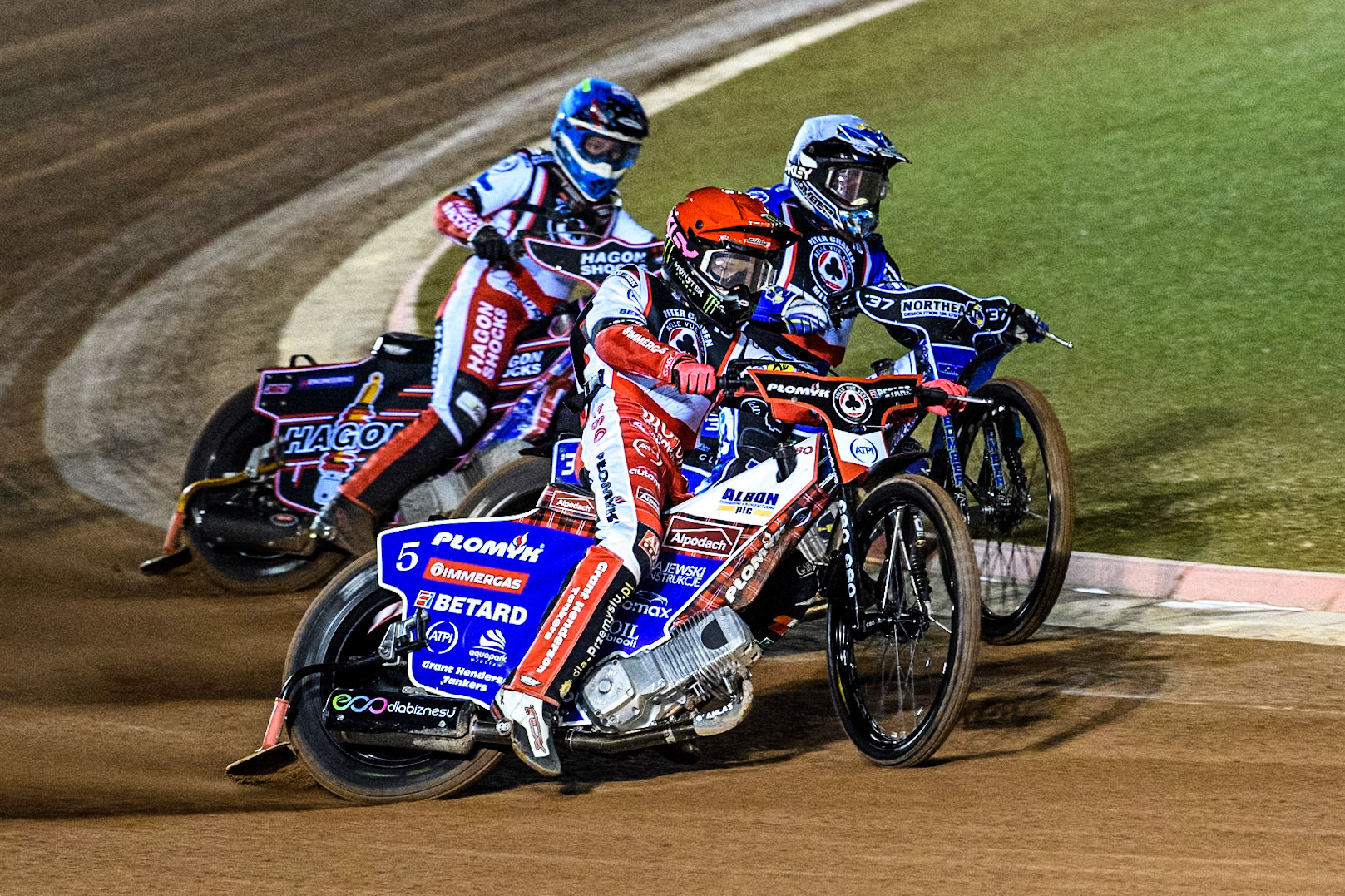 England's Dan Bewley (Red) outside England's Chris Harris with Reserve Sam Hagon (Blue) behind  during the Peter Craven Memorial Trophy meeting at the National Speedway Stadium, Manchester on Monday 18th March 2024. (Photo: Ian Charles | MI News)