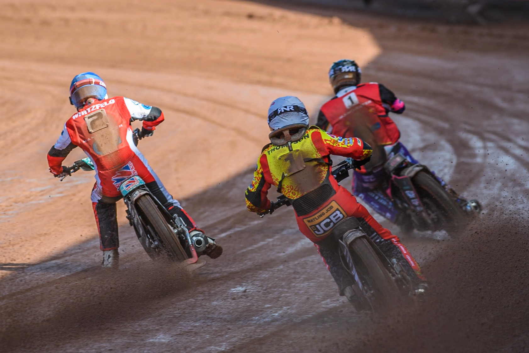 Leicester Lion Cubs' Joe Thompson (White) chases Belle Vue Colts' Chad Wirtzfeld (Blue) and Belle Vue Colts' Ben Trigger  (Red) during the WSRA  National Development League match between Belle Vue Colts and Leicester Lion Cubs at the National Speedway Stadium, Manchester on Friday 29th March 2024. (Photo: Ian Charles | MI News)