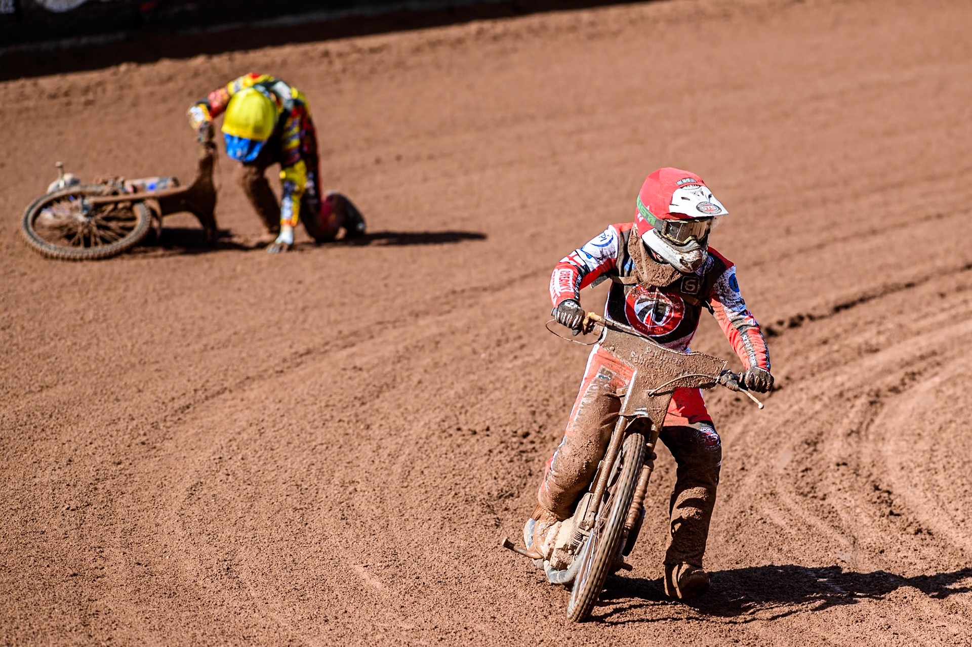 Belle Vue Colts' Jack Shimelt (Red) rides past faller Leicester Lion Cubs' Sonny Springer  during the WSRA  National Development League match between Belle Vue Colts and Leicester Lion Cubs at the National Speedway Stadium, Manchester on Friday 29th March 2024. (Photo: Ian Charles | MI News)