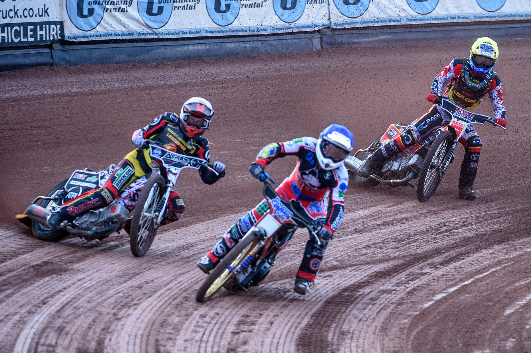 MANCHESTER, UK. JULY 29TH  Paul Bowen  (Blue) picks up some drive causing him to fall as he leads Joe Lawlor  (White) and Tom Spencer   (Yellow)  during the National Development League match between Belle Vue Colts and Leicester Lion Cubs at the National Speedway Stadium, Manchester on Thursday 29th July 2021. (Credit: Ian Charles | MI News)