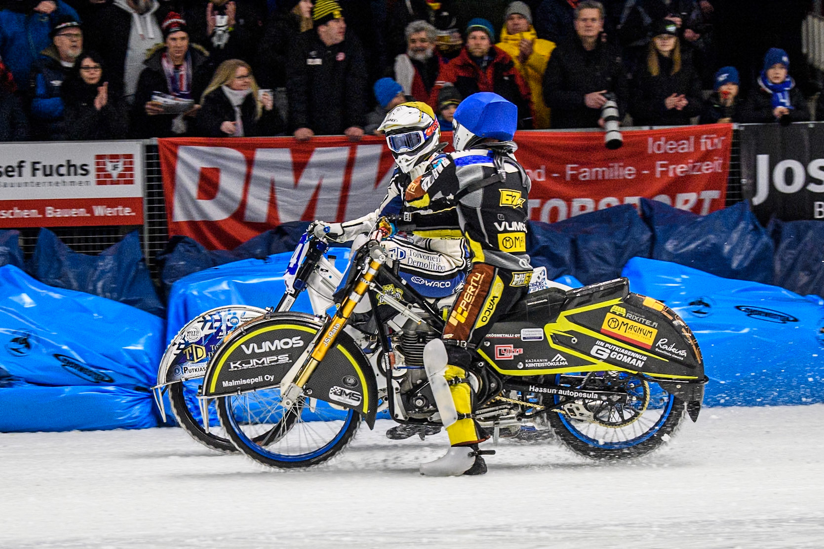 Heikki Huusko (67) of Finland in Blue congratulates Max Koivula (24) of Finland in Yellow on his win during the Ice Speedway Gladiators World Championship Final 1 at Max-Aicher-Arena, Inzell on Saturday 15th March 2025. (Photo: Ian Charles | MI News)